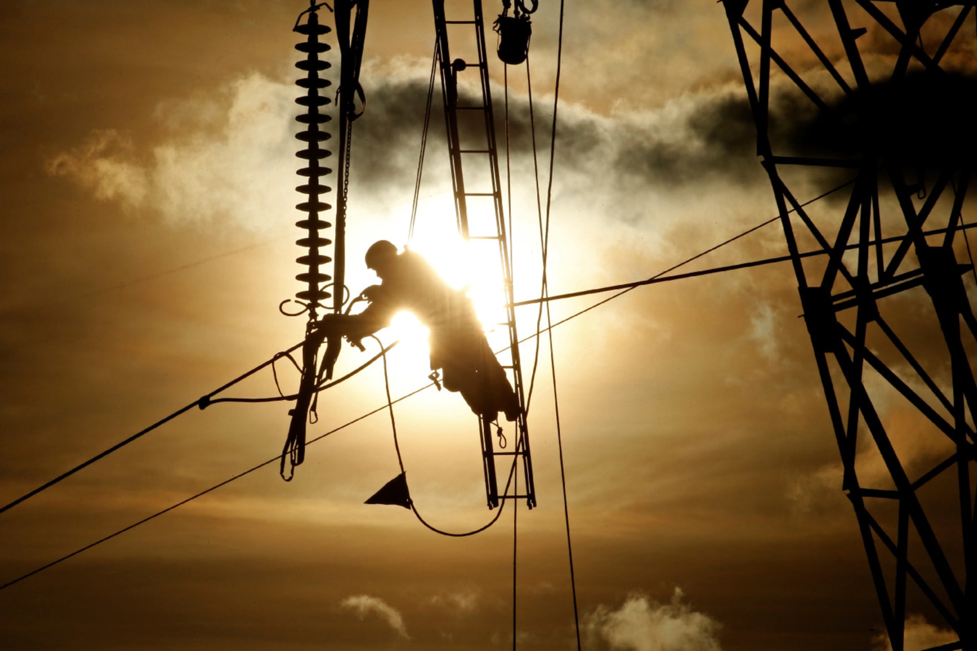 A maintenance technician repairs electricity power lines during sunset in Roye, France, on February 11, 2019.