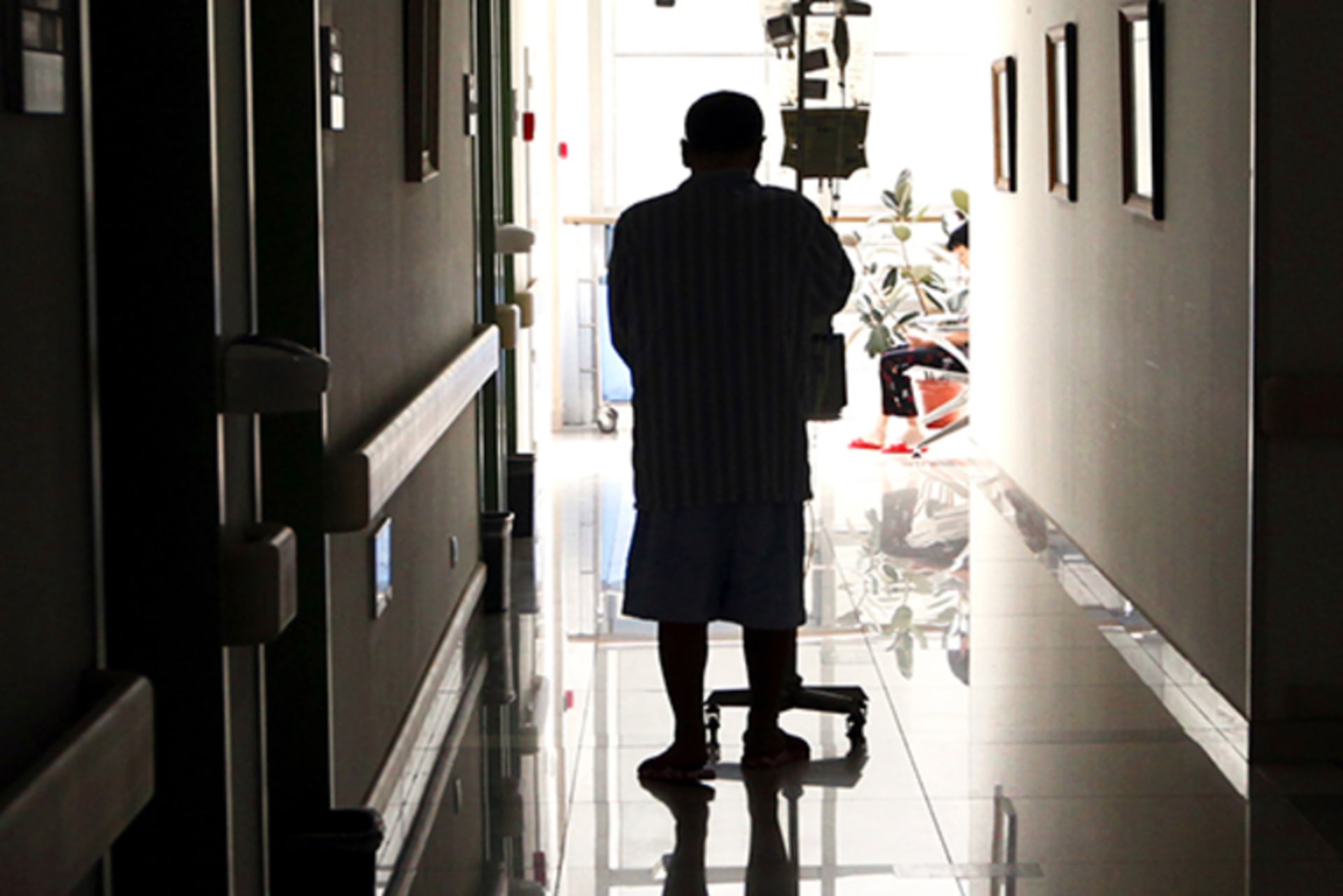 A cancer patient pushes his drip stand as he walks down the hallway of the Beijing Cancer Hospital on July 12, 2011.