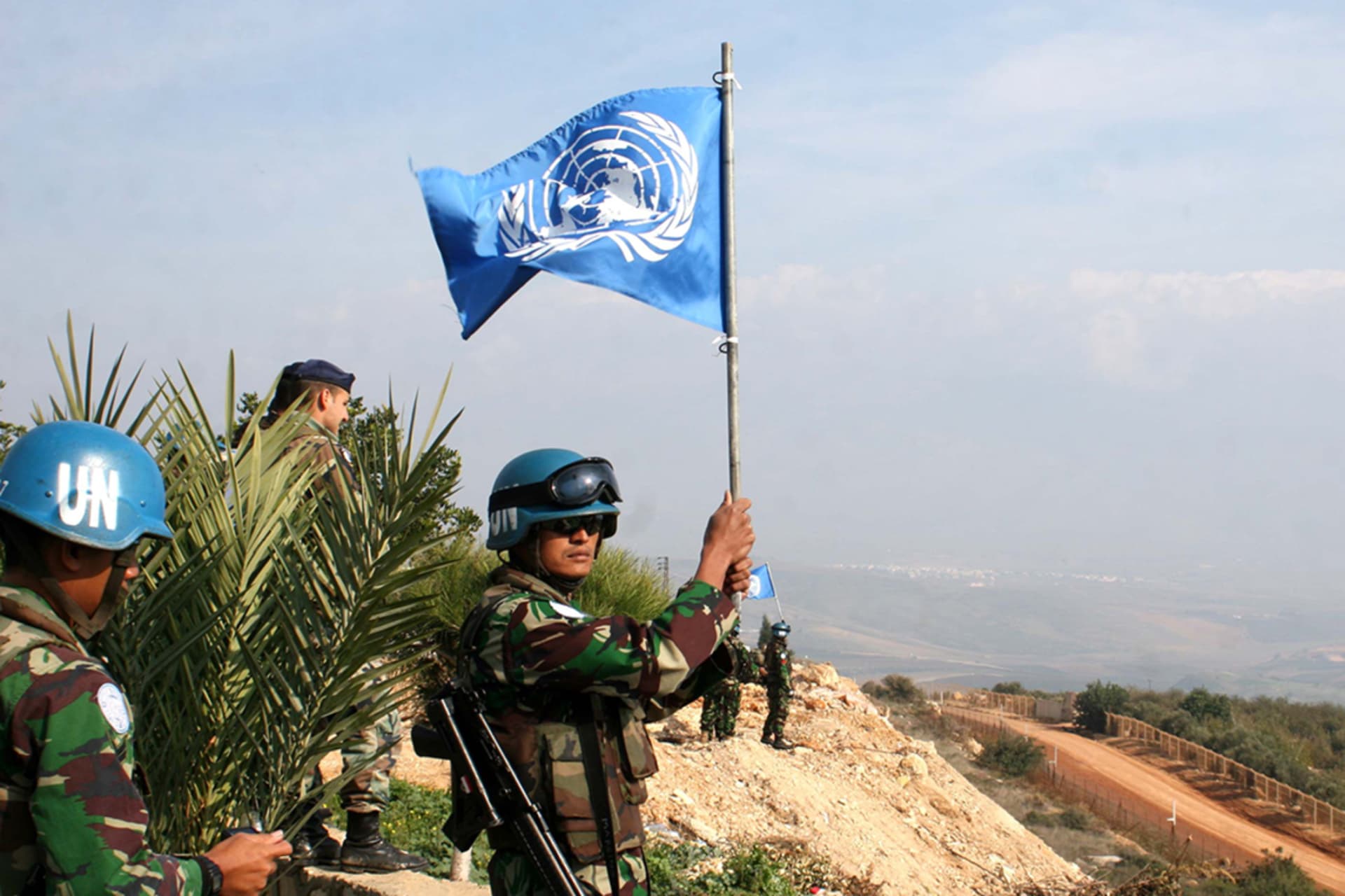 <p>An Indonesian peacekeeper waves a UN flag on the border between Lebanon and Israel in the southern Lebanese village of Adaisseh on November 30, 2009.</p>
<p>&nbsp;</p>
