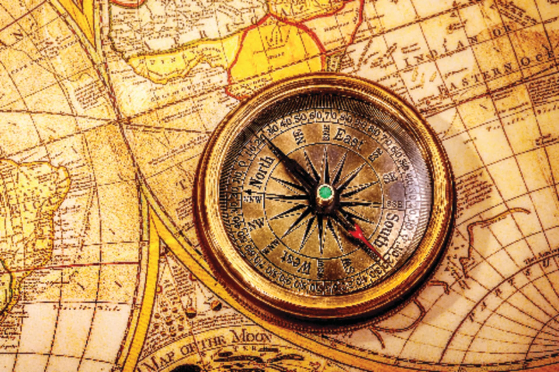A compass sitting on top of a map of the world
