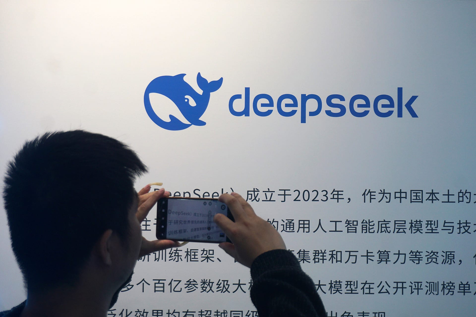 A visitor takes photos of the display board of DeepSeek at a mall on April 23, 2026 in Hangzhou, Zhejiang Province of China.