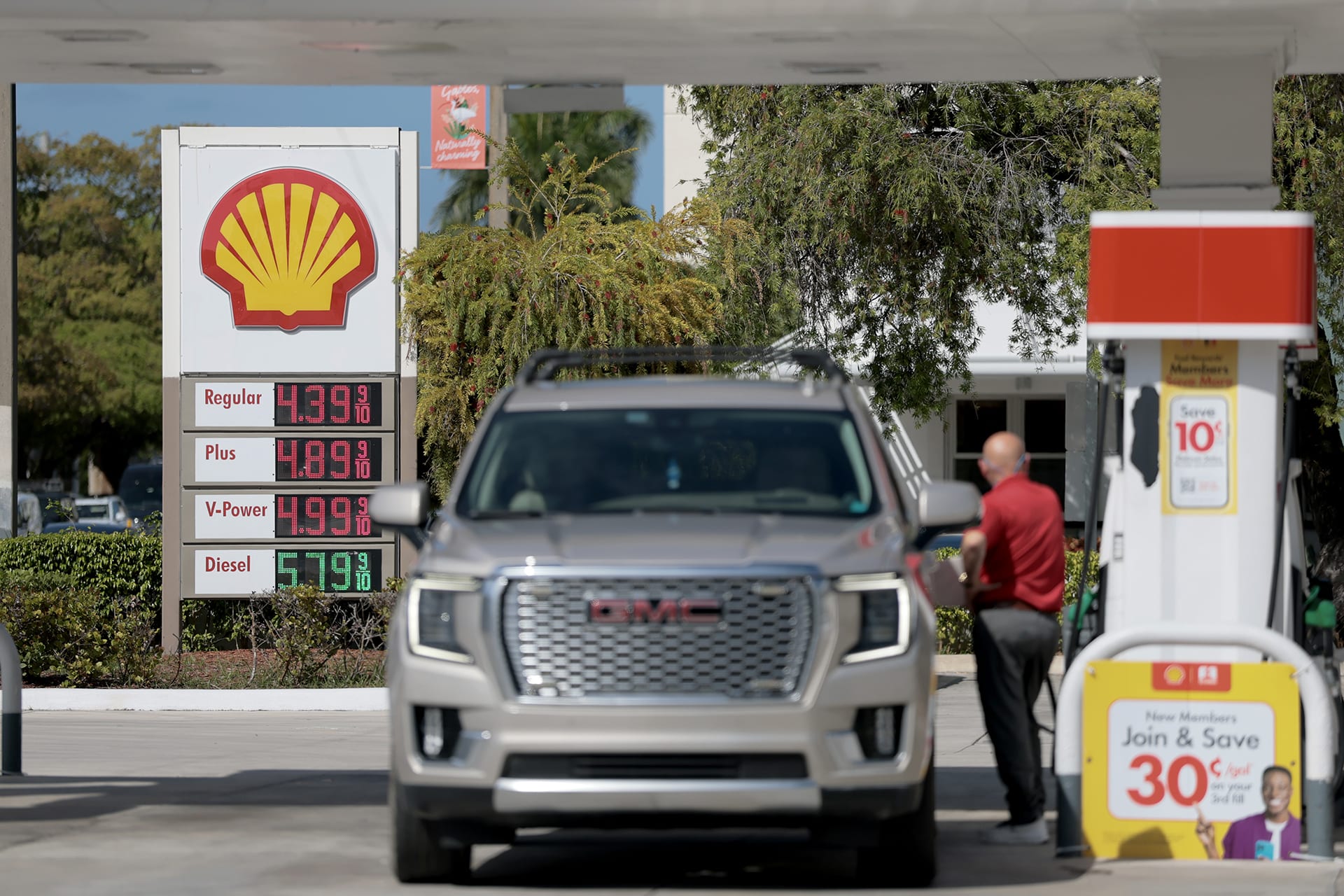 Fuel prices are displayed on a sign as a customer fills their vehicle at a gas station on April 13, 2026 in Miami, Florida.