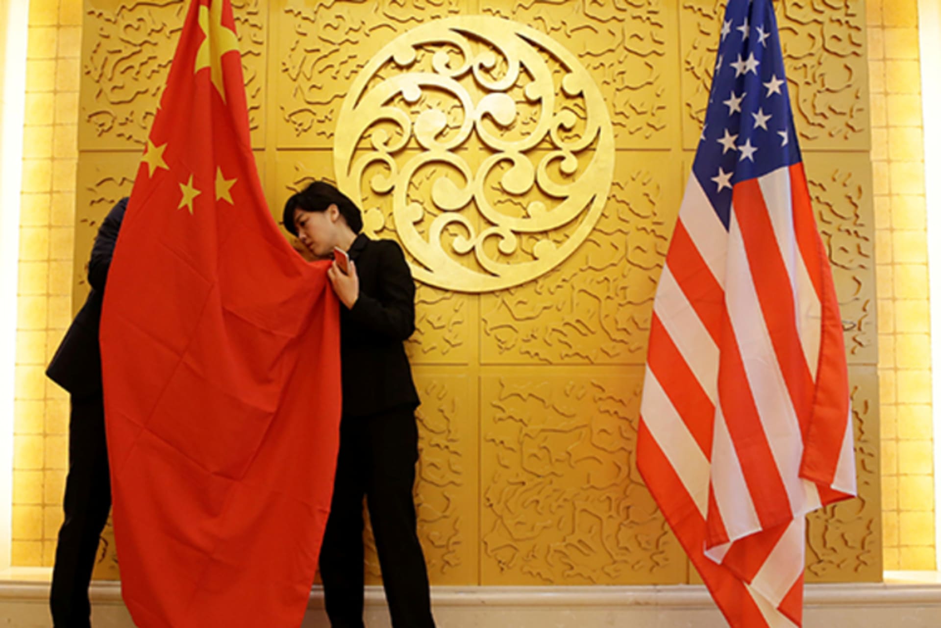 Staff members set up Chinese and U.S. flags for a meeting between Chinese Transport Minister Li Xiaopeng and U.S. Secretary of Transportation Elaine Chao at the Ministry of Transport of China in Beijing on April 27, 2018.