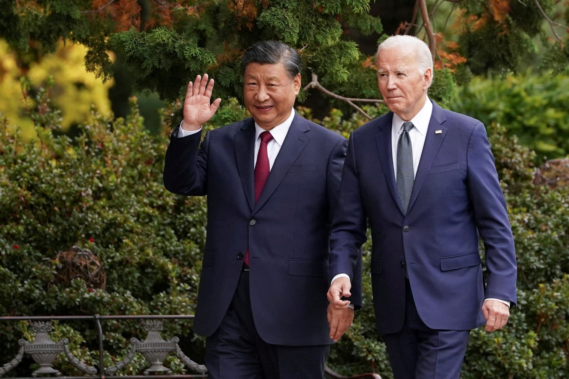 Chinese President Xi Jinping waves as he walks with U.S. President Joe Biden.