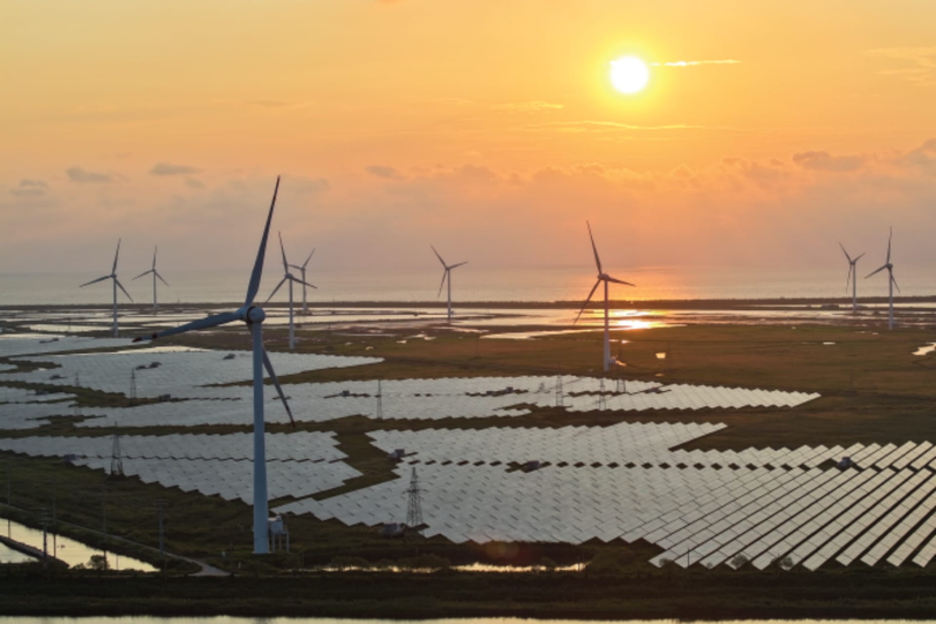 Wind turbines spin above solar panels in Yancheng, China on August 15, 2024.