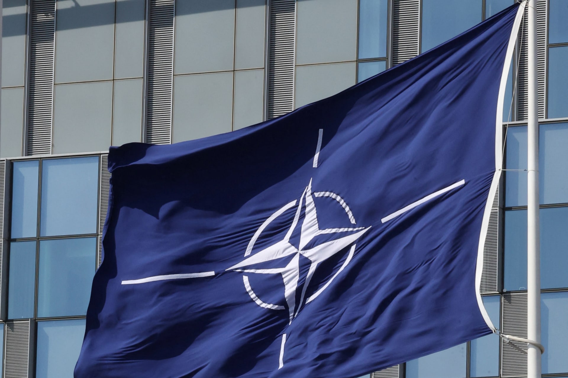 The flags of NATO, the U.S. and Britain flutter at NATO headquarters in Brussels