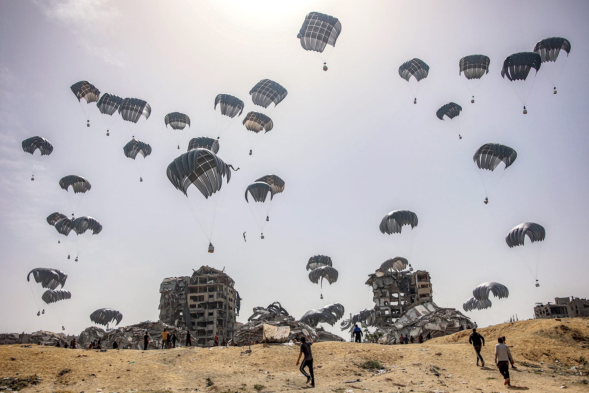 Parachutes fill the landscape with aid during an aid drop in Gaza.