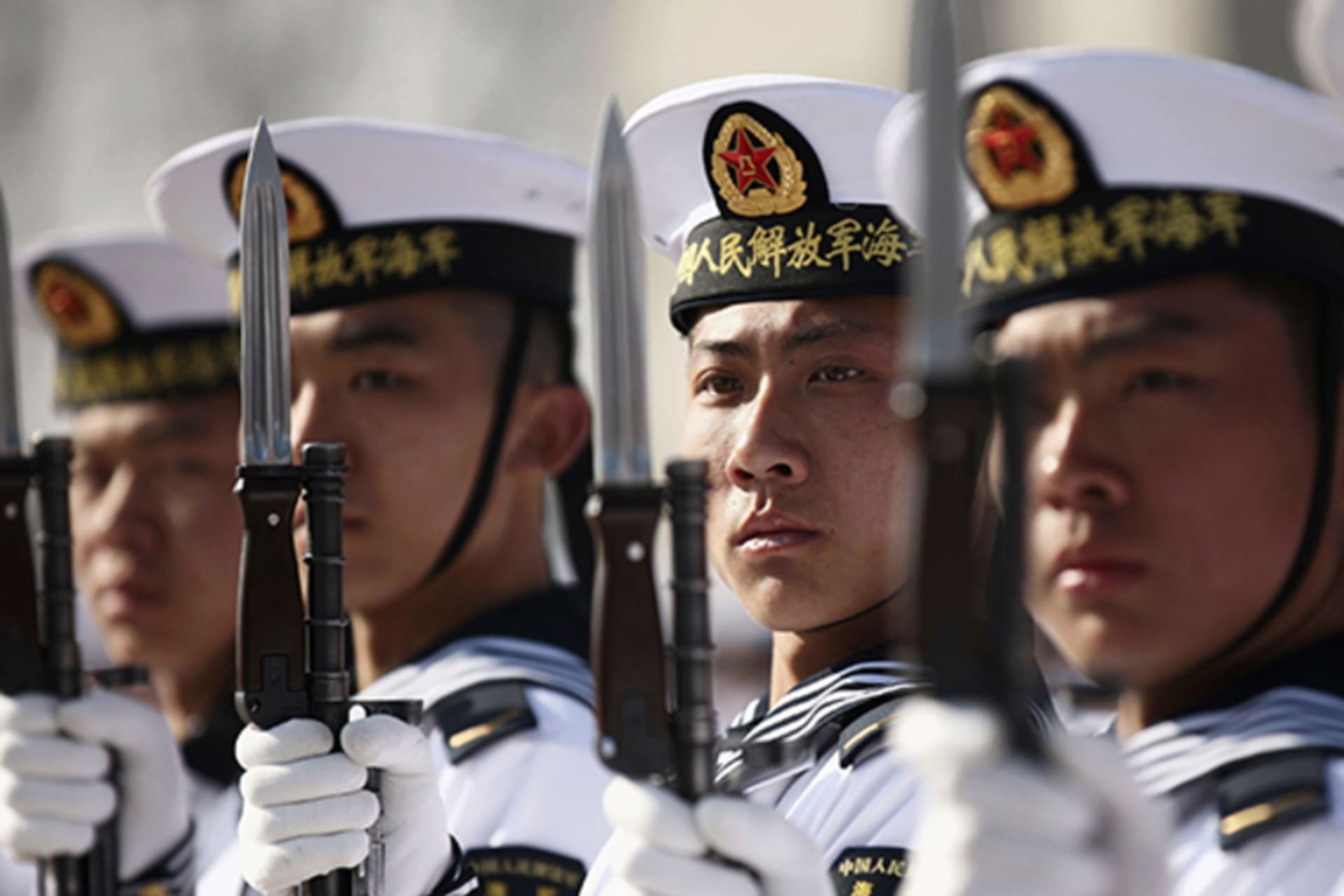 New recruits of the Chinese Navy fleet stand with their guns during the parade marking the end of their first training session in Qingdao on March 4, 2013.