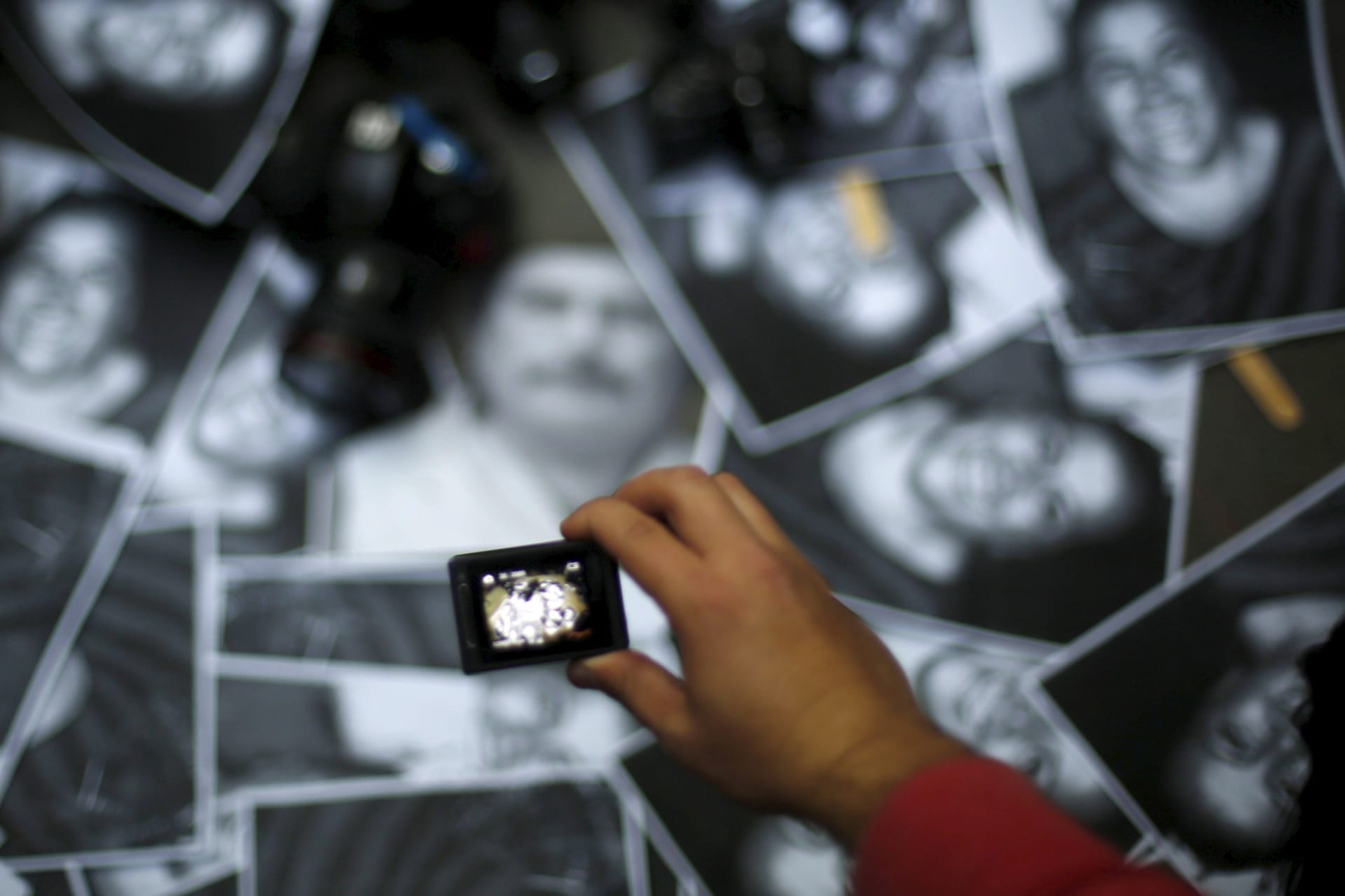A woman takes photos of images of murdered journalists during a demonstration against murder of the journalist Anabel Flores outside the Government of Veracruz building in Mexico City
