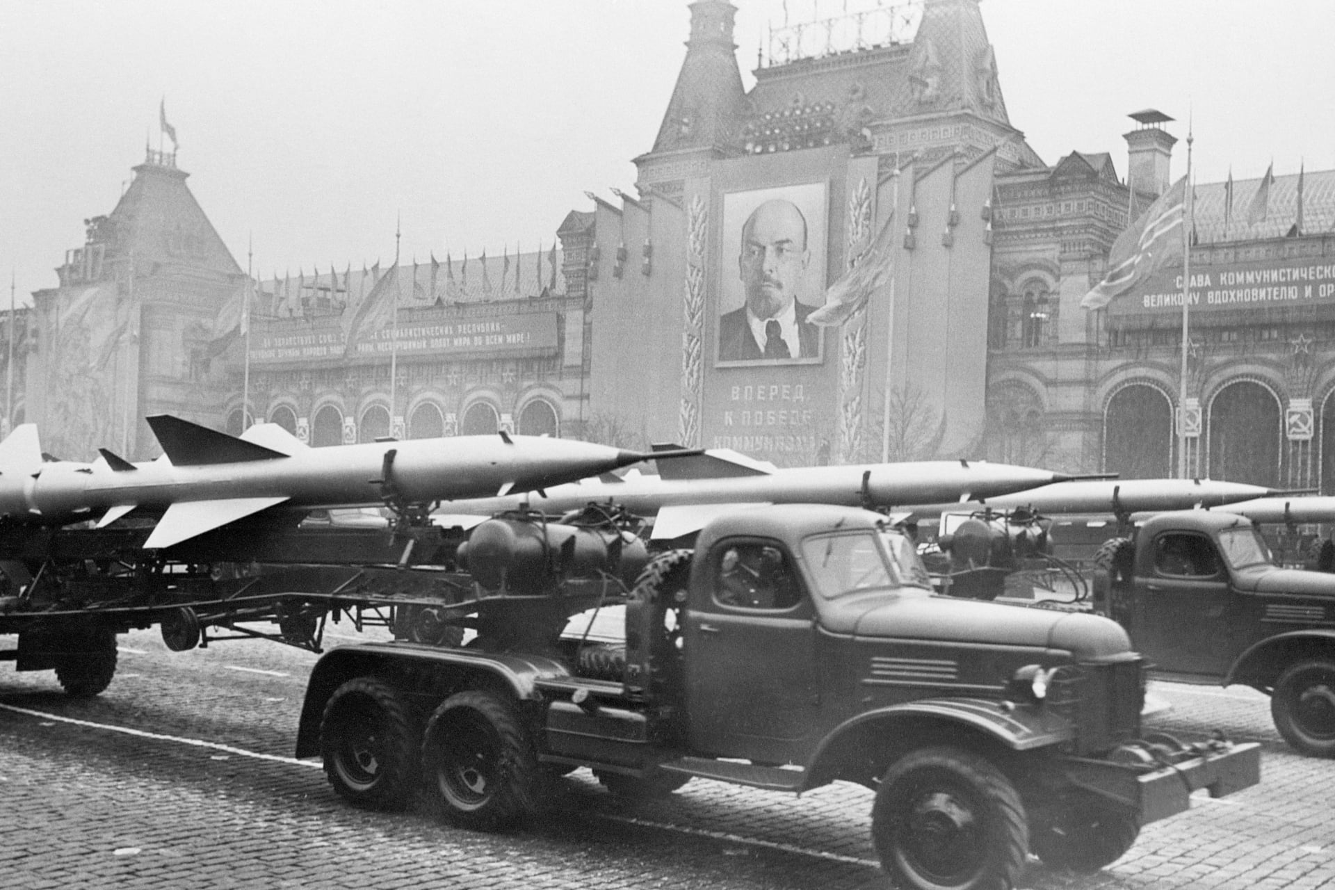 Military trucks pull trailers of short-range, two-stage missiles with twin tail assembly past the Kremlin in 1957.