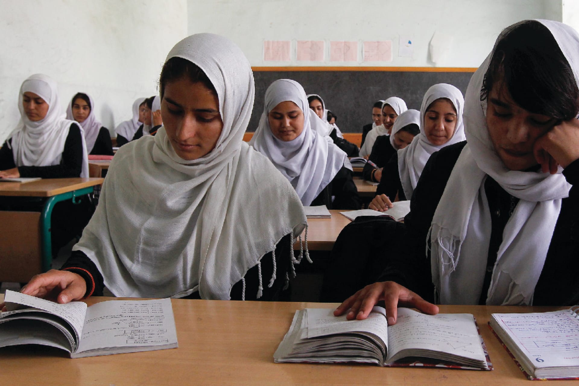 Girls read notes while studying in a school in Kabul.