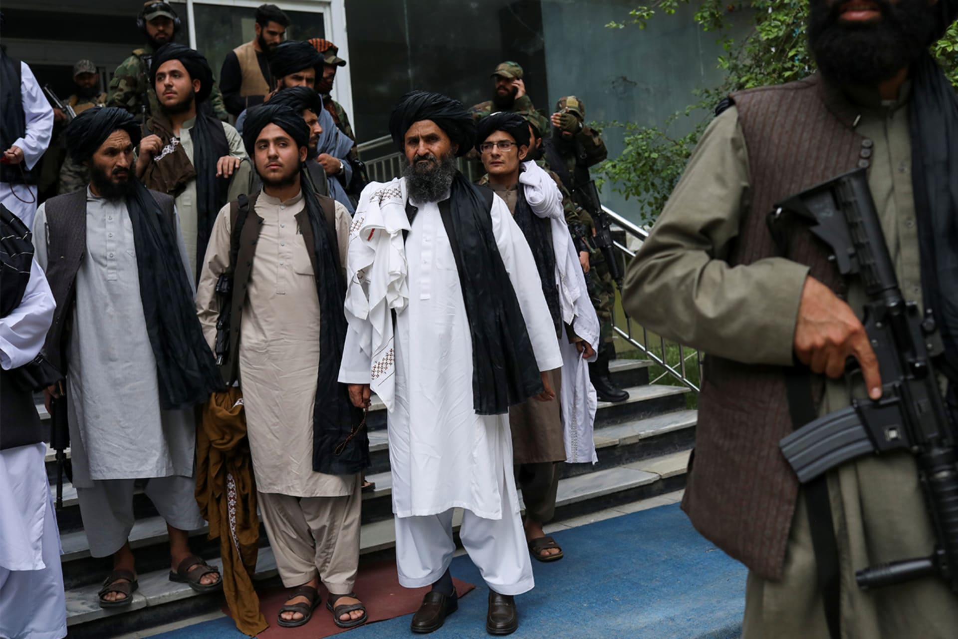 A Taliban fighter stands guard with a gun as Afghan Deputy Prime Minister Mullah Abdul Ghani Baradar and other Taliban leaders attend the death anniversary of Mullah Mohammad Omar, the late leader and founder of Taliban in Kabul, Afghanistan.