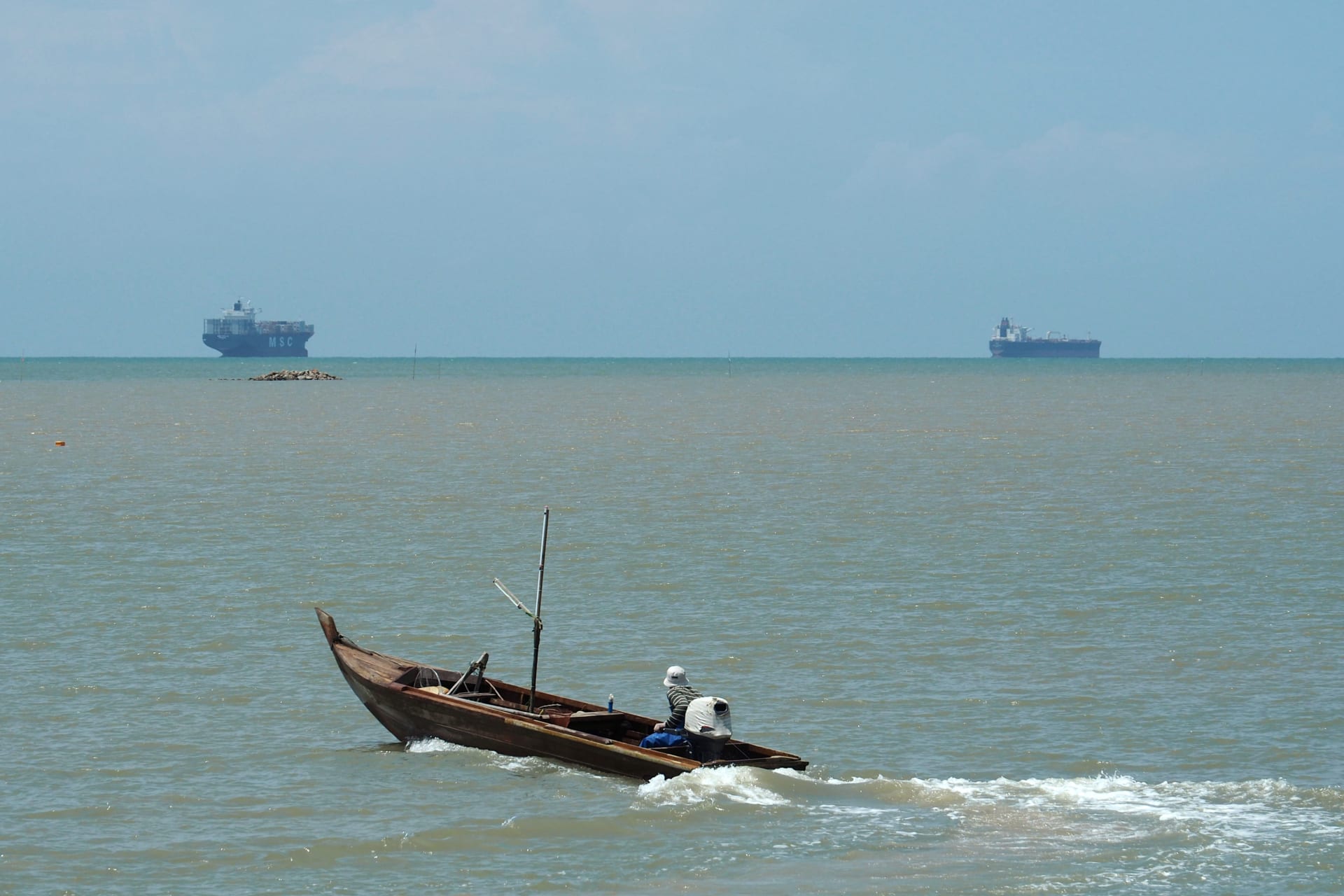 A fisherman drives his boat off the southern coast of Johor