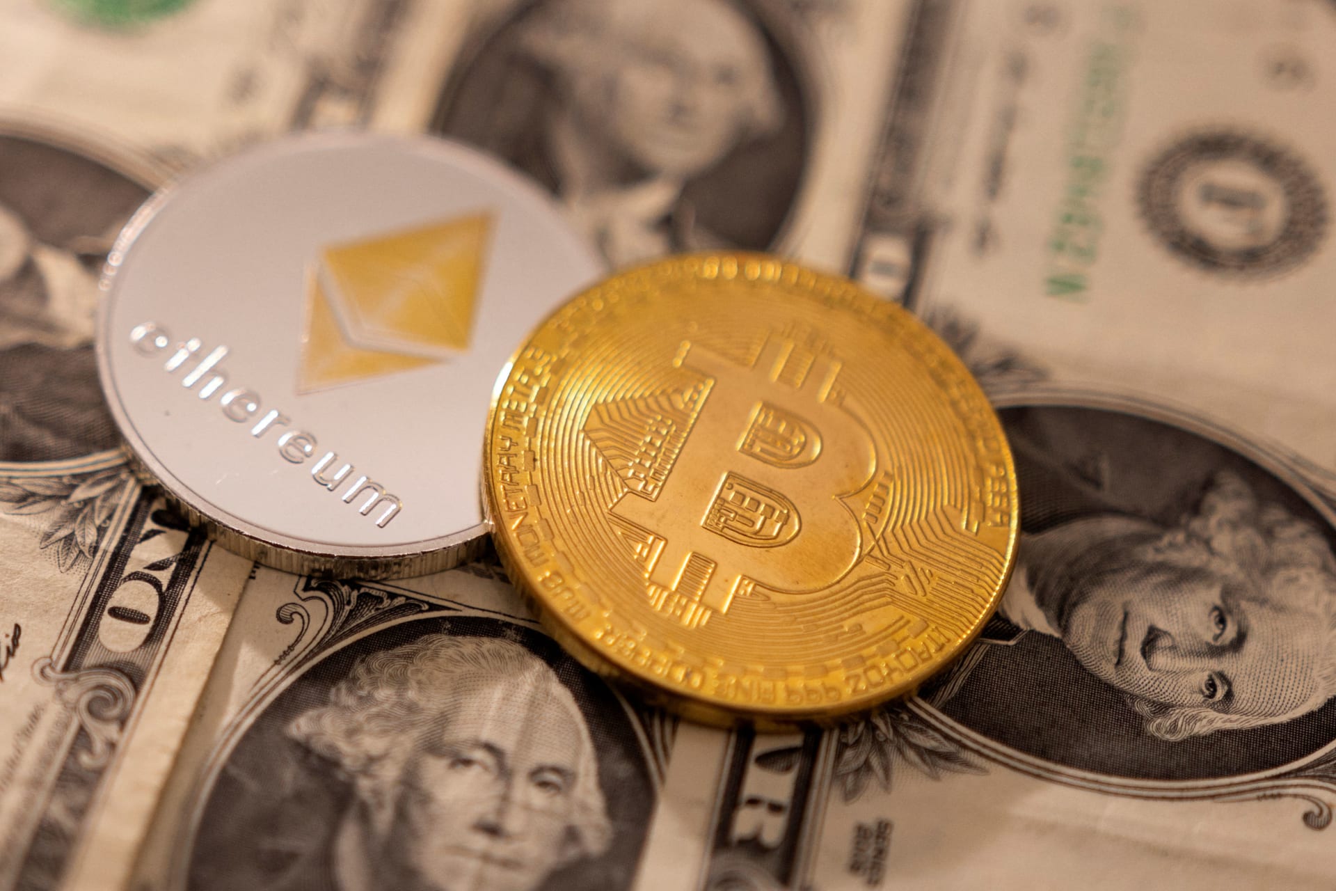 A representations of cryptocurrency Bitcoin and Ethereum placed on U.S. dollars