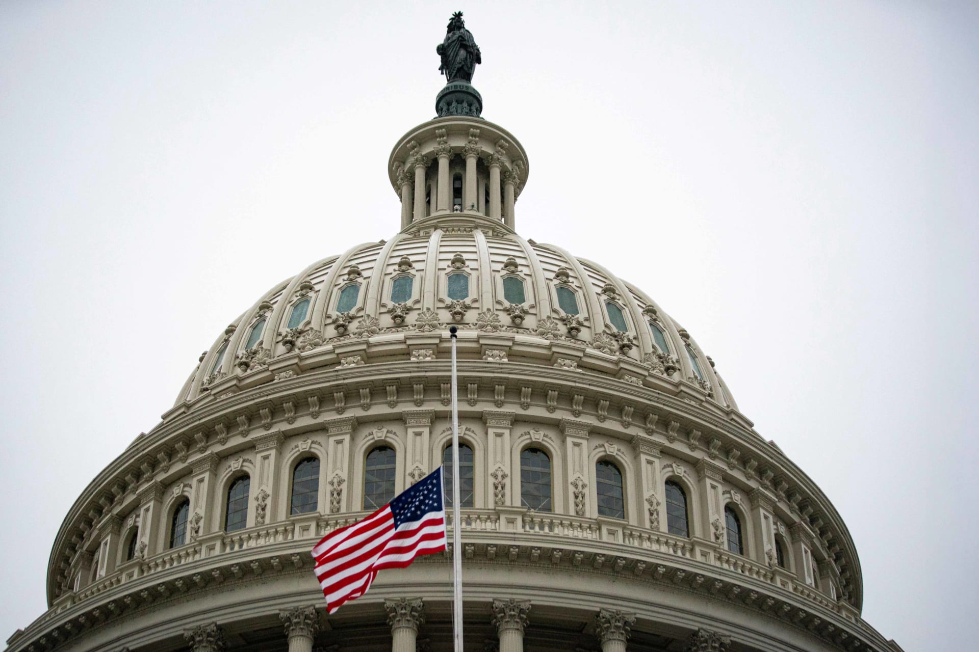 The American flag flies at half staff at the U.S. Capitol Building.
