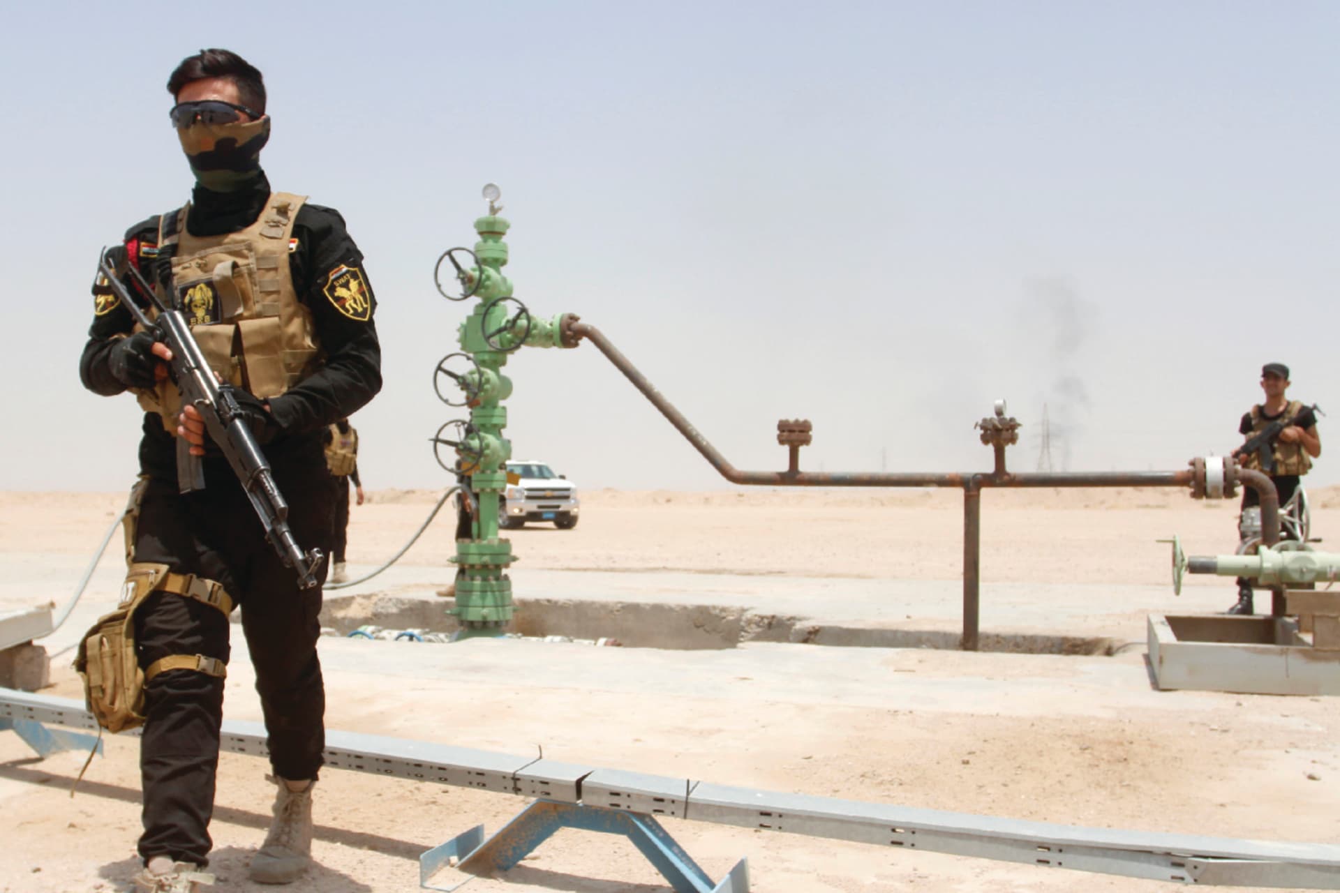 Iraqi security force members walk with their weapons during a patrolling tour for the media at the oil fields in Basra.