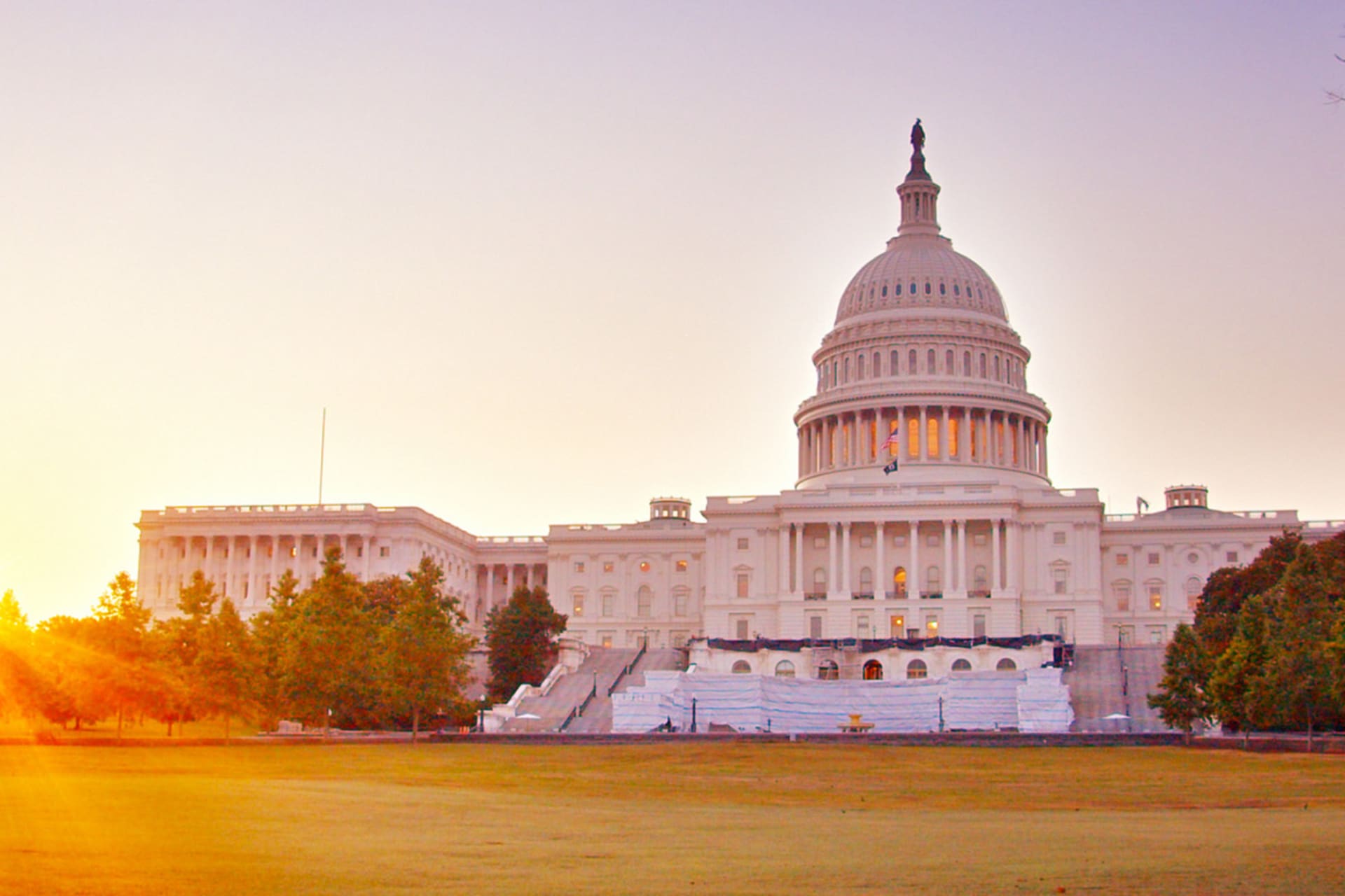 The sun rises behind the U.S. Capitol building.