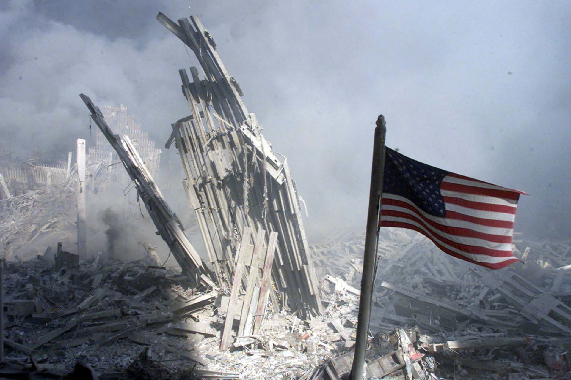 <p>An American flag flies near the base of the destroyed World Trade Center in New York City on September 11, 2001.</p>