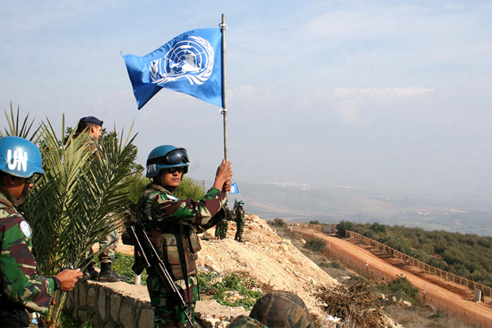 An Indonesian UNIFIL peacekeeper waves a UN flag on the border between Lebanon and Israel in the southern Lebanese village of Adaisseh on November 30, 2009.