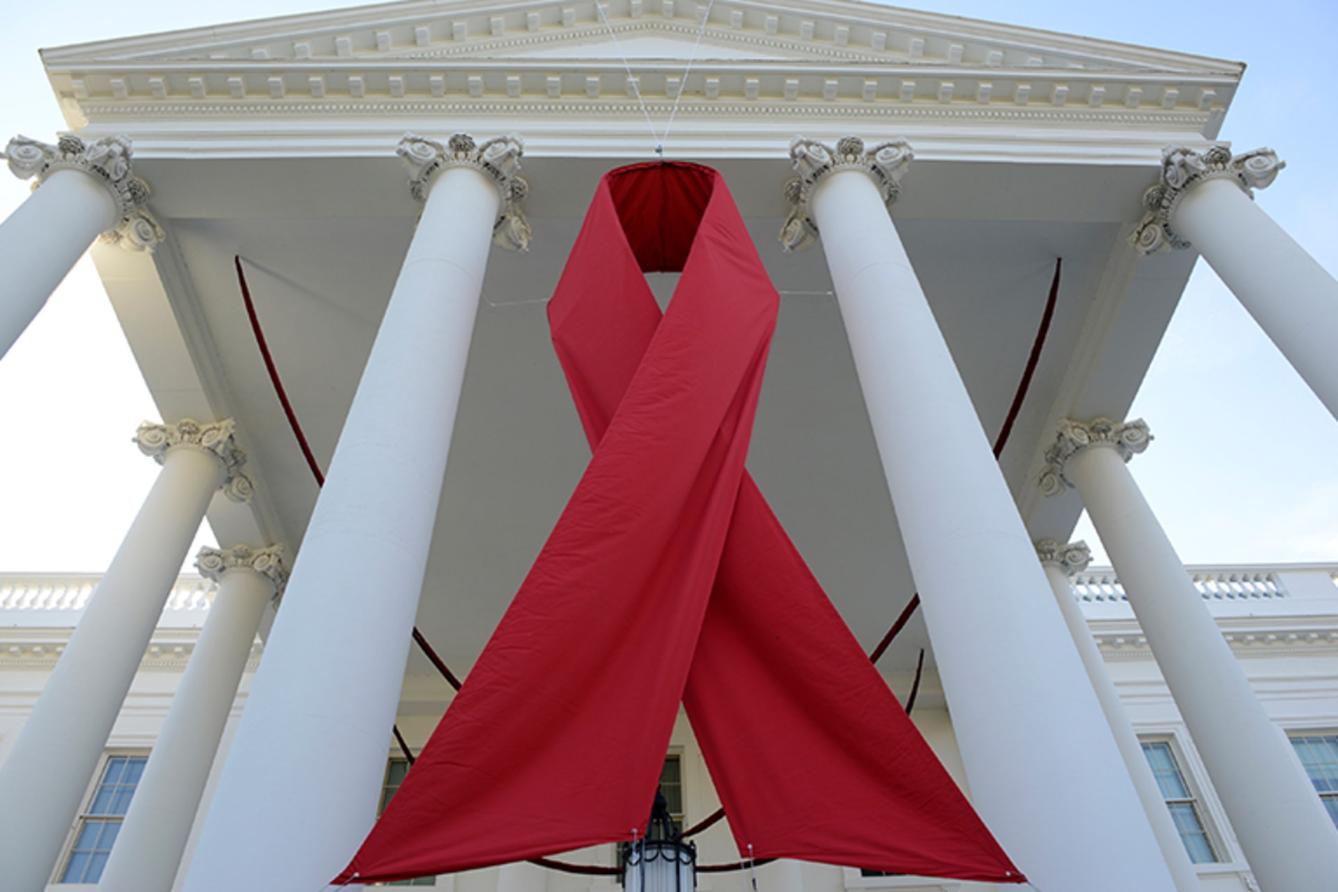 A giant red ribbon hangs from the North Portico of the White House to mark World AIDS Day on December 1, 2013, in Washington.