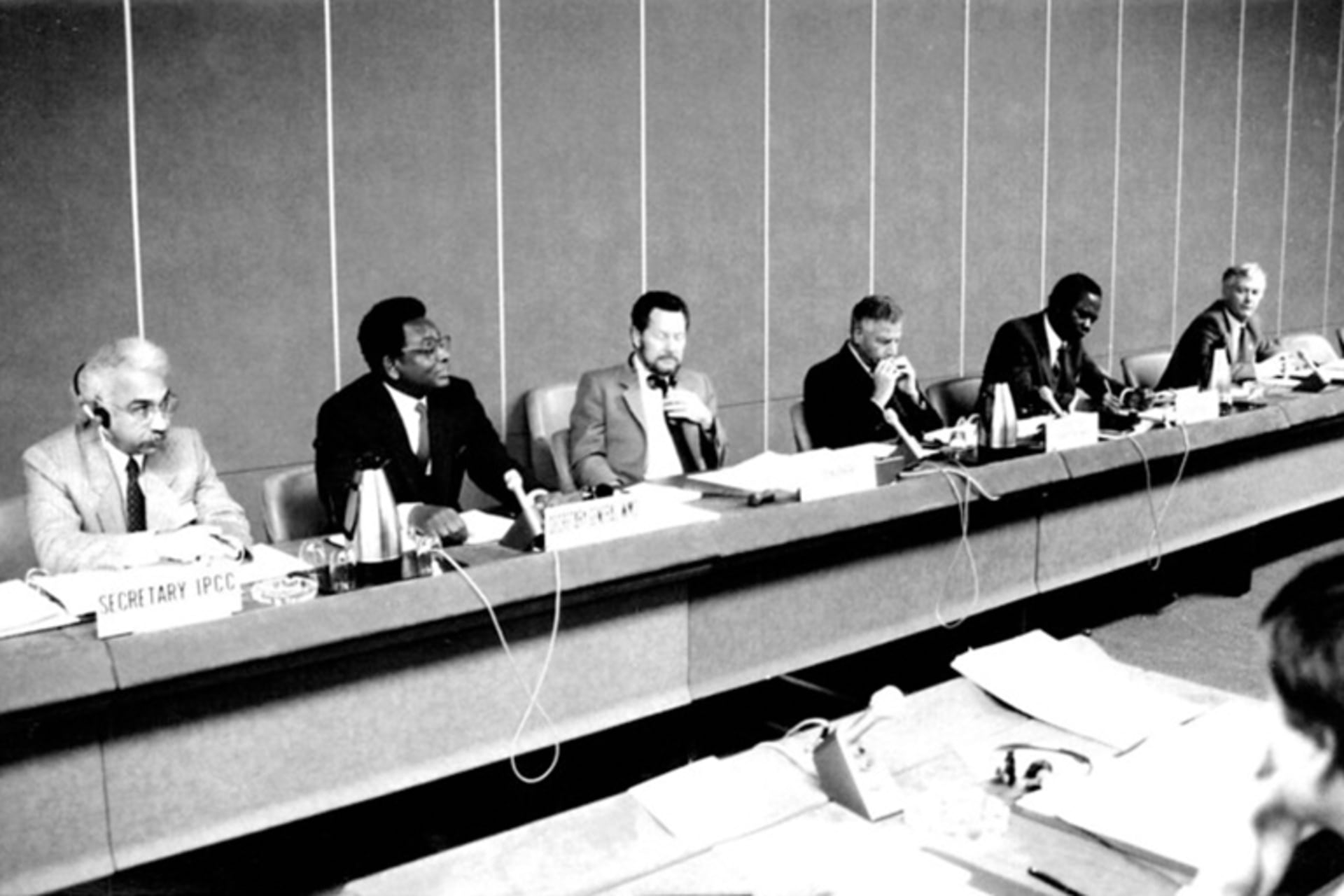 People sit on a panel with placards in front of them at the first session of the Intergovernmental Panel on Climate Change was held in Geneva, Switzerland in November 1988.