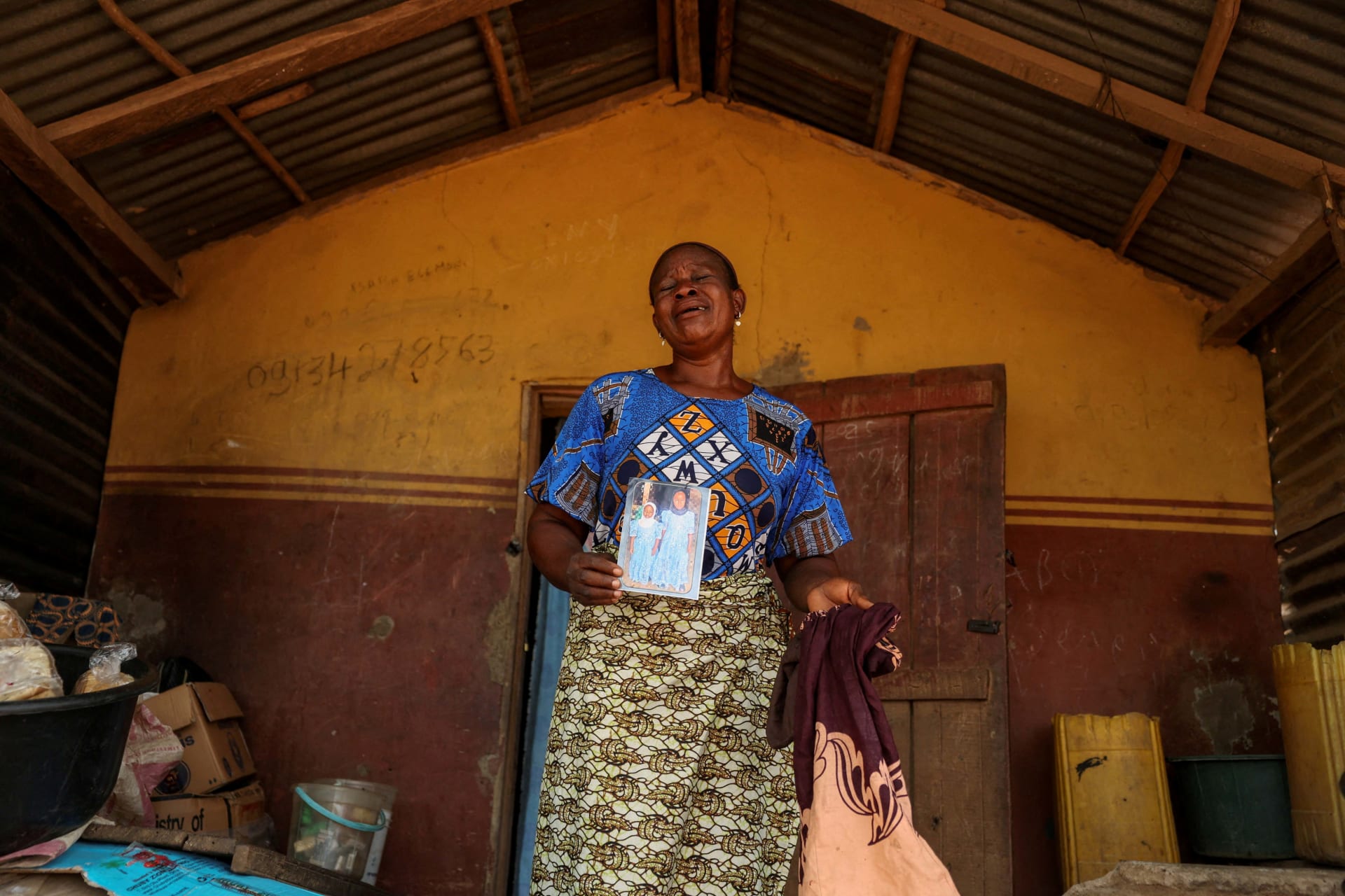 <p>Aduke Balogun, whose daughter was among dozens of pupils and teachers abducted in a large-scale school attack in southwestern Nigeria, reacts while displaying her daughter’s photograph and clothing after an interview with Reuters at her home in Yawota, Oyo state, Nigeria, on June 2, 2026.</p>
