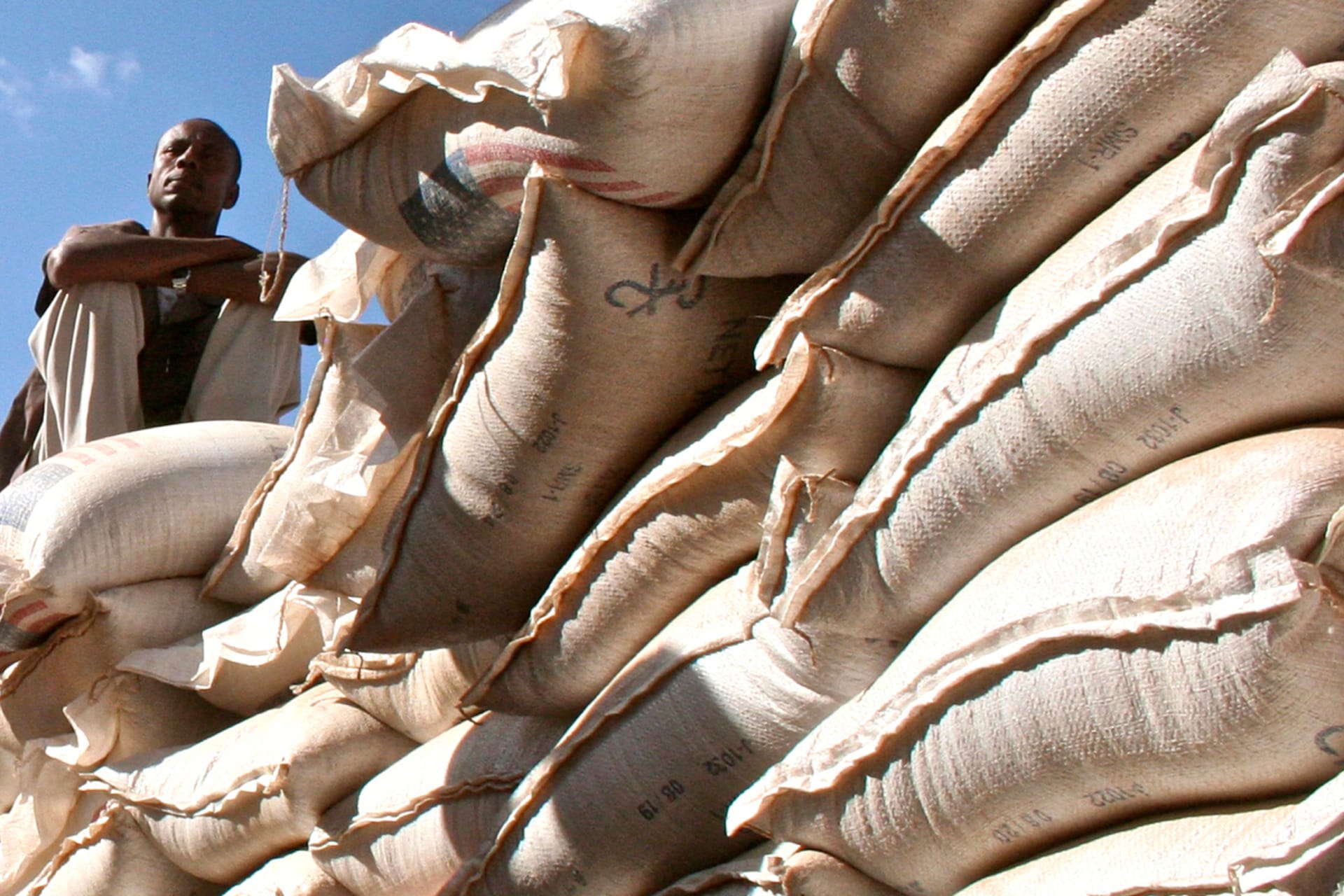 An unidentified government official sits on sacks of wheat donated by the U.S. at a food distribution point near Jijiga, eastern Ethiopia.