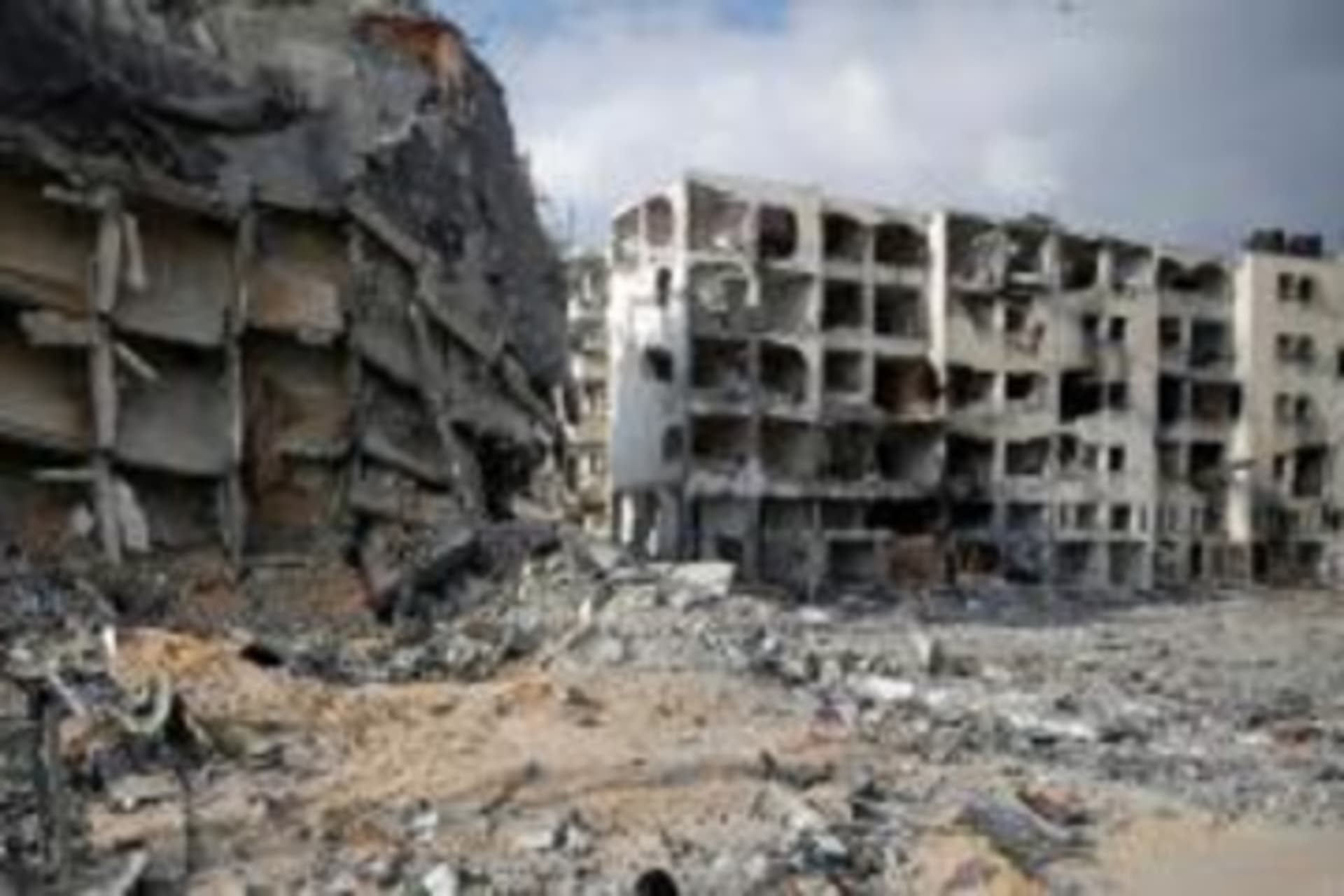 A Palestinian woman walks past buildings destroyed by what police said were Israeli air strikes and shelling in the town of Beit Lahiya in the northern Gaza Strip on August 3, 2014.