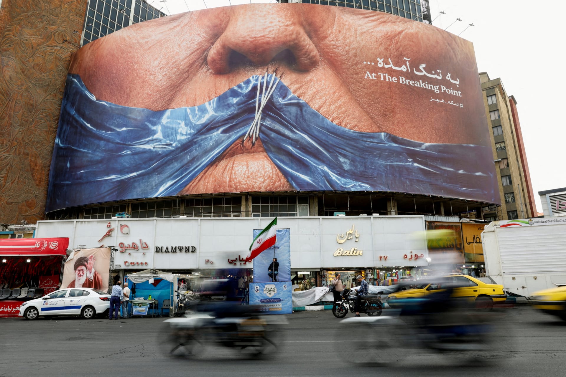 People drive past an anti-U.S. billboard depicting U.S. President Donald Trump and the Strait of Hormuz, in Tehran, Iran, on May 17, 2026.