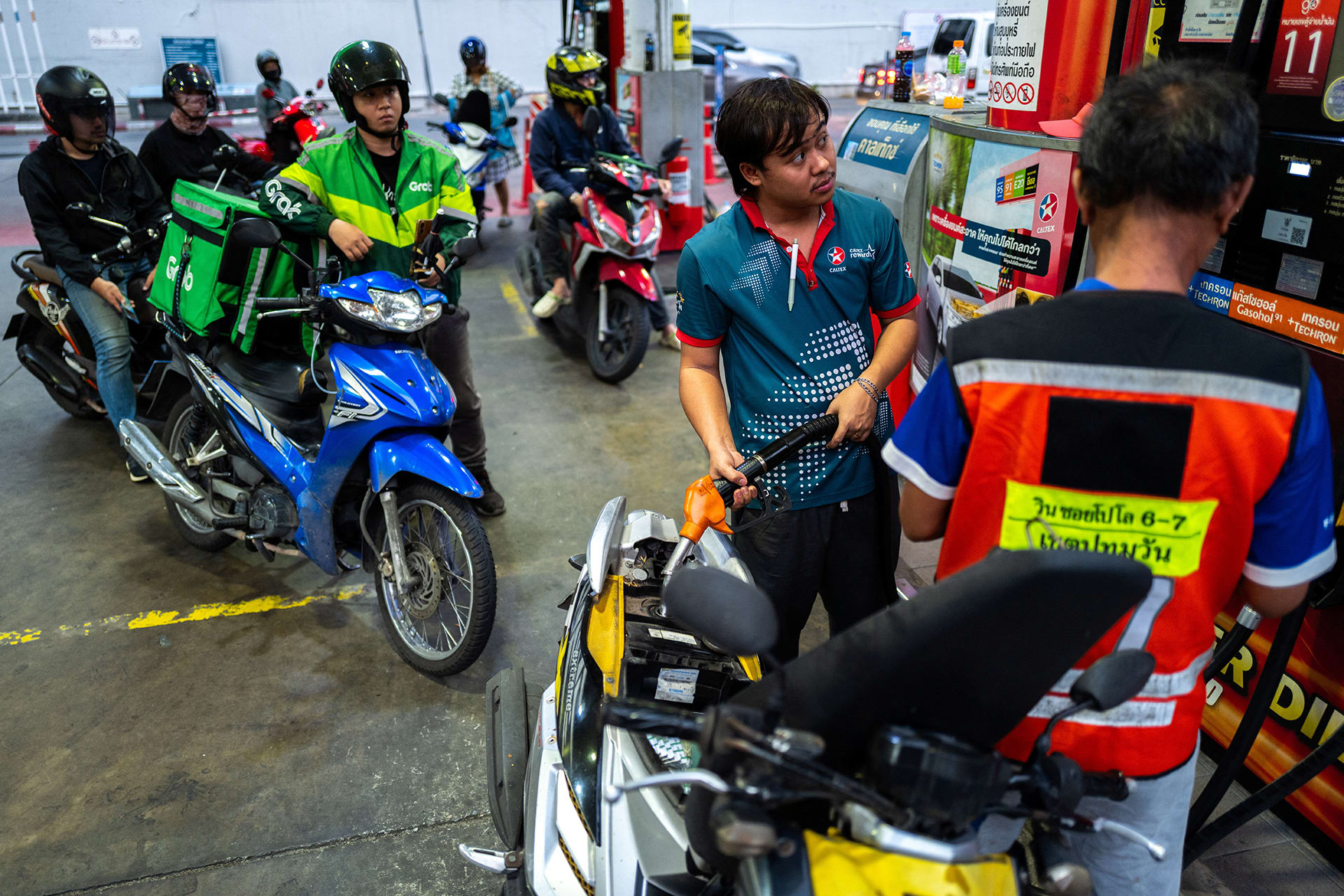 Riders with vehicles queue to fill up fuel at a gas station amid the U.S.-Israeli conflict with Iran, in Bangkok, Thailand, March 26, 2026.