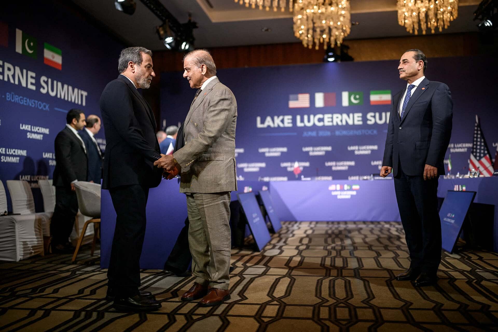 Iran's Foreign Minister Abbas Araqchi shakes hands with Pakistan's Prime Minister Shehbaz Sharif next to Pakistan's Chief of Army Staff Field Marshal Asim Munir prior to a quadrilateral meeting between the United States, Iran, Pakistan and Qatar at the Burgenstock luxury hotel complex overlooking Lake Lucerne, Switzerland, on June 21, 2026.