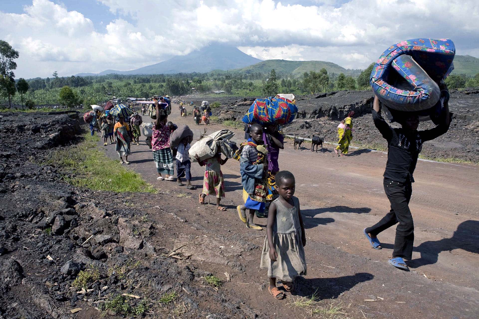 Refugees flee with their belongings from the city of Kibati to Goma