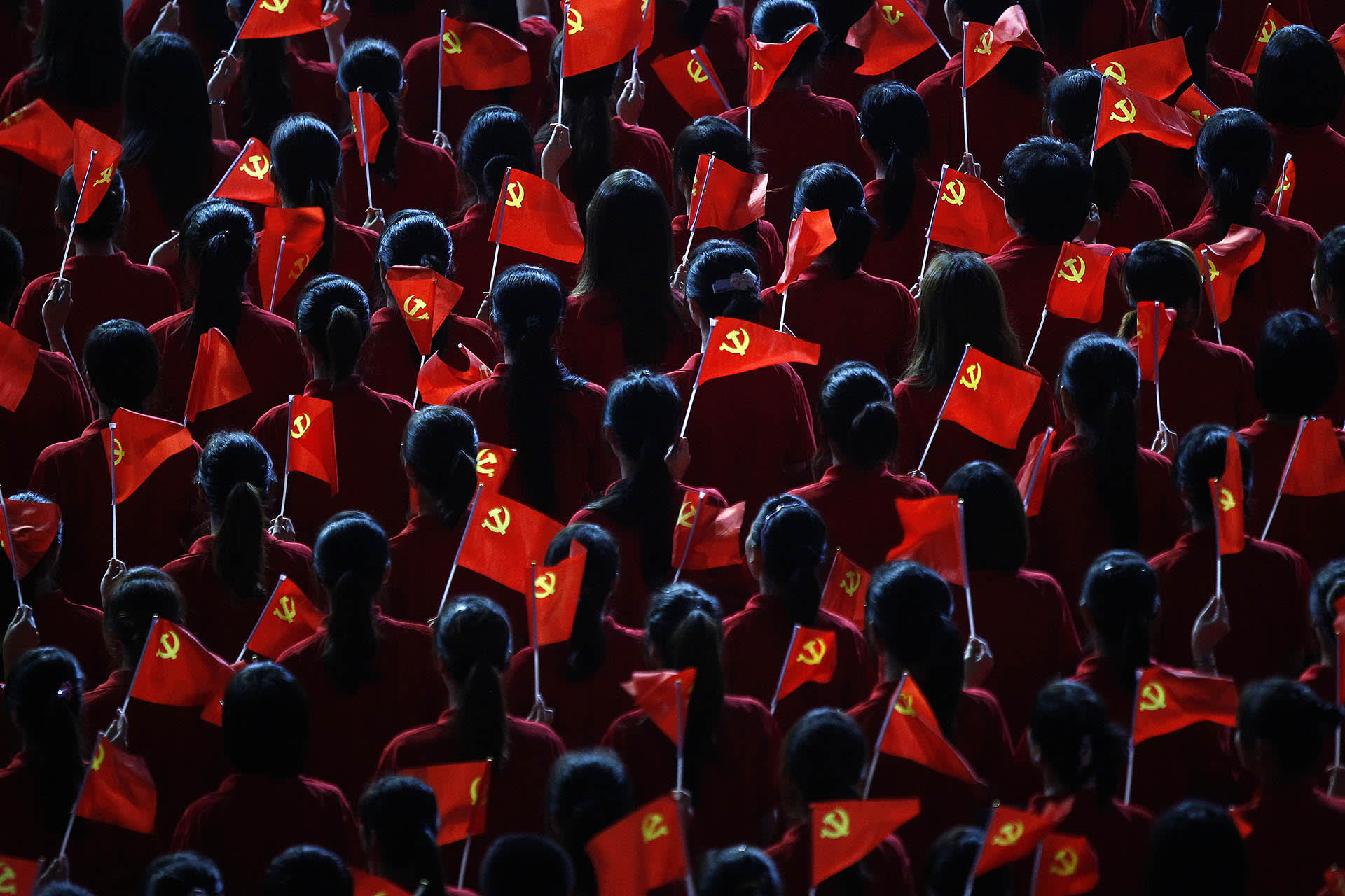 Performers hold flags of the Communist Party of China during an event to celebrate the upcoming 90th anniversary of the founding of the party, in Shanghai