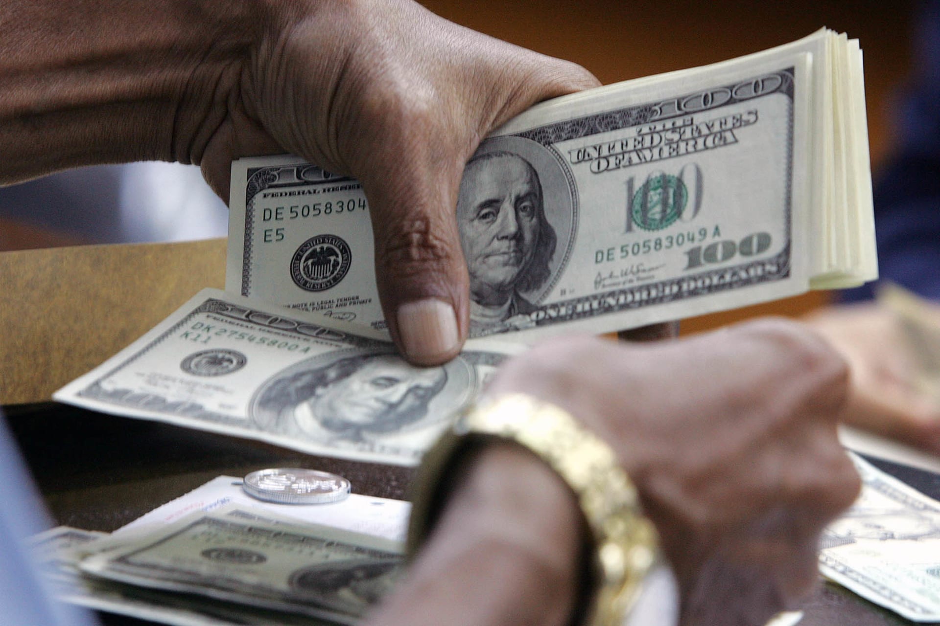 An Indonesian customer counts US dollar bills in Jakarta.