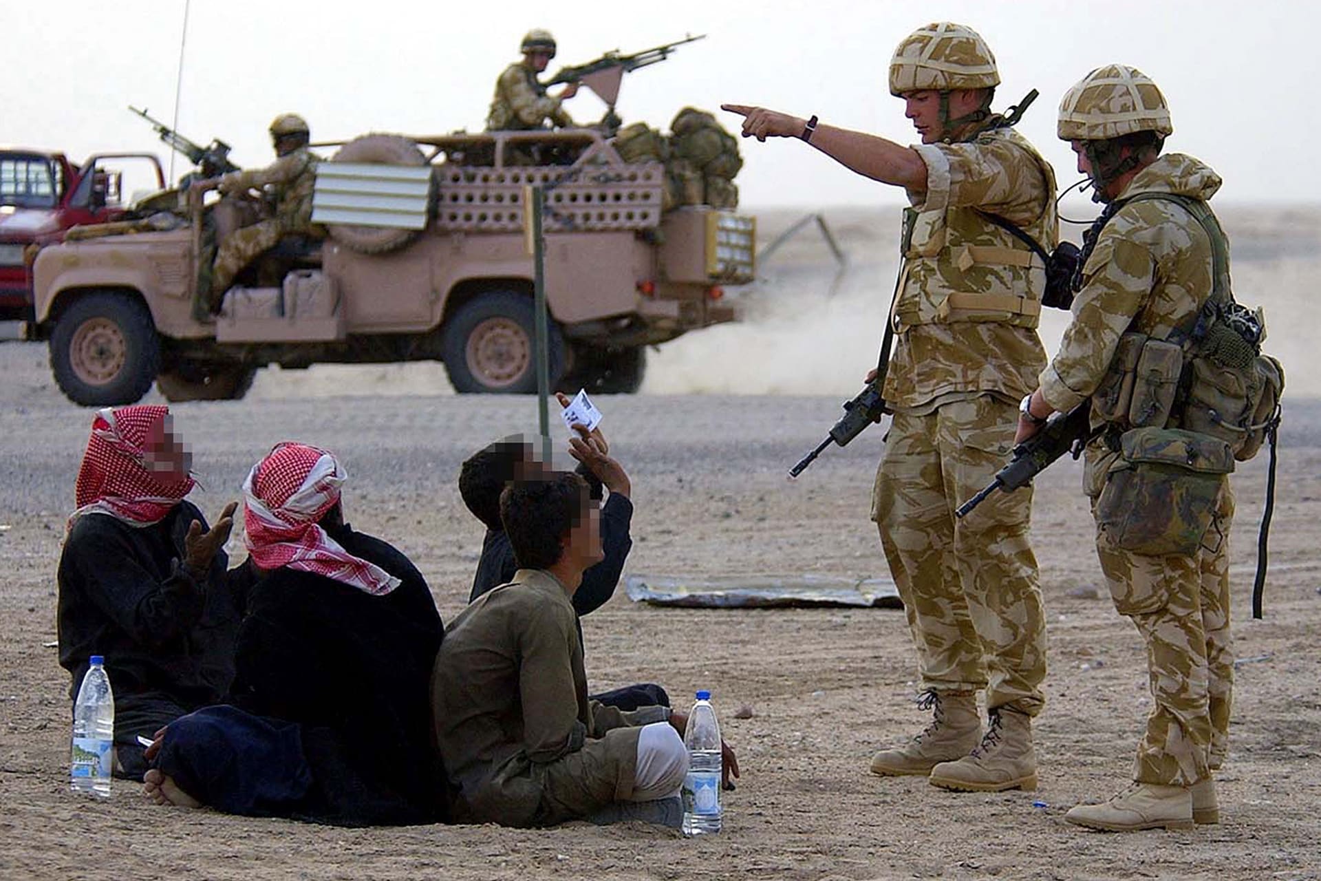 BRITISH SOLDIERS STOP SUSPECTED IRAQI SOLDIERS AT A CHECKPOINT INSOUTHERN IRAQ.