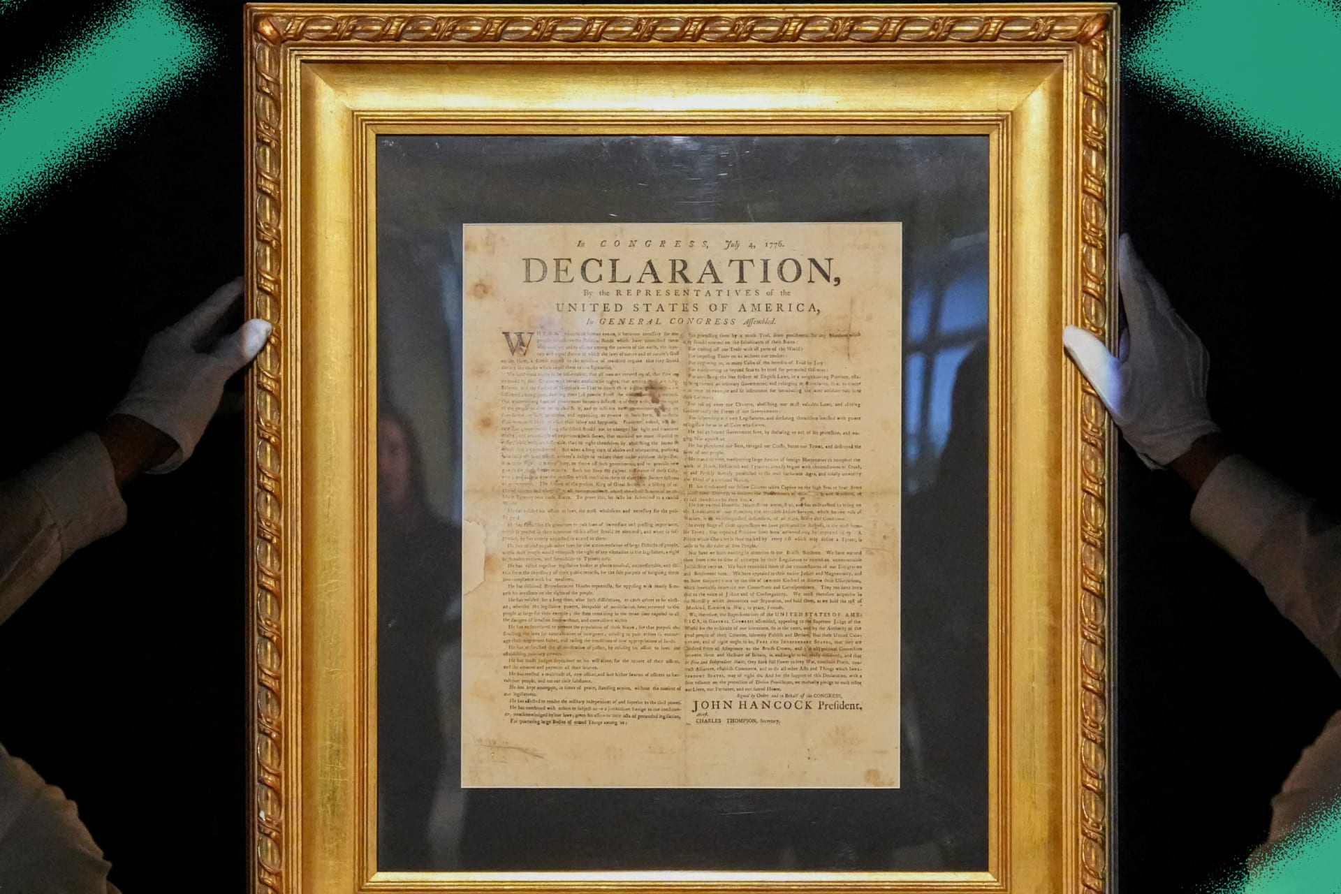Handlers hold a July 1776 printing of the Declaration of Independence during a press preview at Sotheby's in New York City on January 17, 2025.