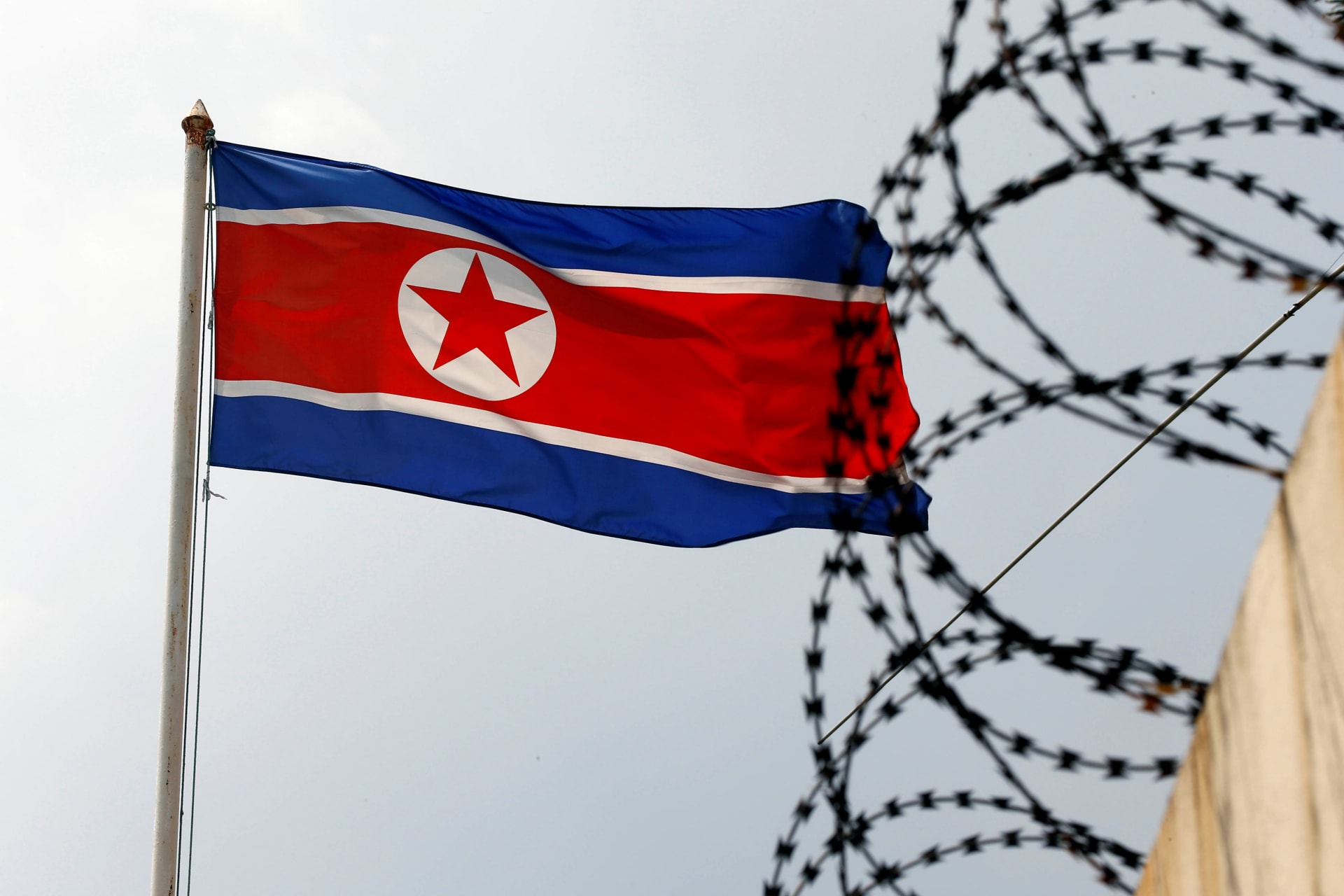 The North Korea flag flutters next to concertina wire at the North Korean embassy in Kuala Lumpur