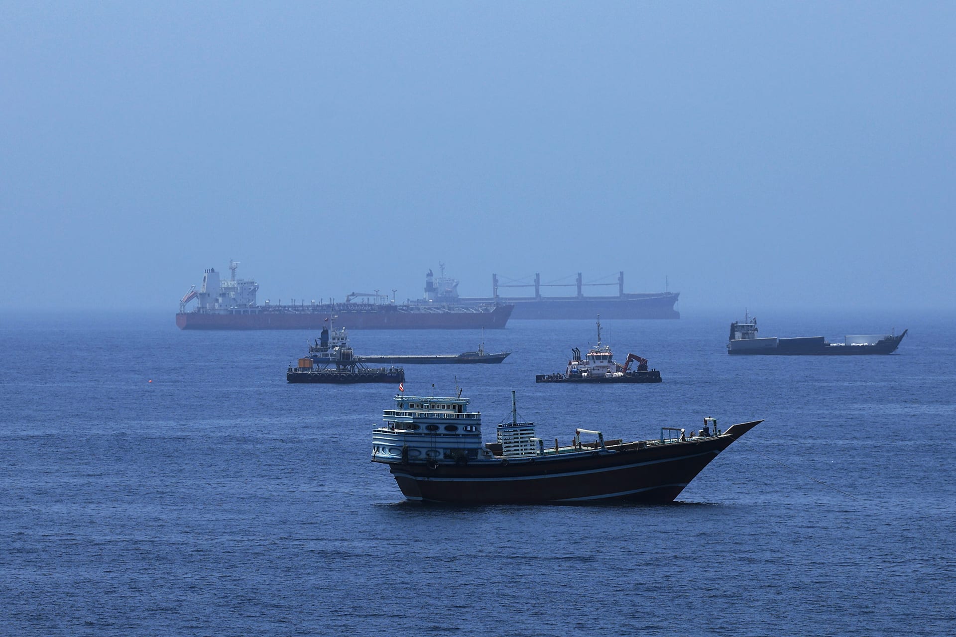 A view of commercial cargo vessels and crude oil tankers are anchored in the Gulf of Oman, off the coast of Muscat, Oman, on June 21, 2026, as they prepare to transit through the critical Strait of Hormuz.