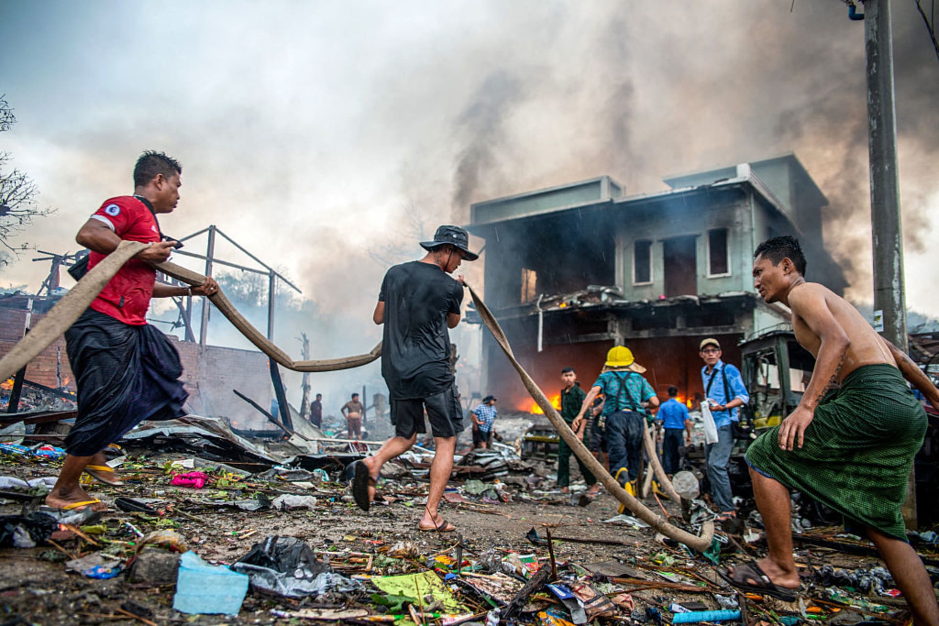 People extinguish a fire in a building that was destroyed in a bombardment carried out by Myanmar's military in Thabeikkyin Township in Mandalay Region of Central Myanmar on April 19, 2025.