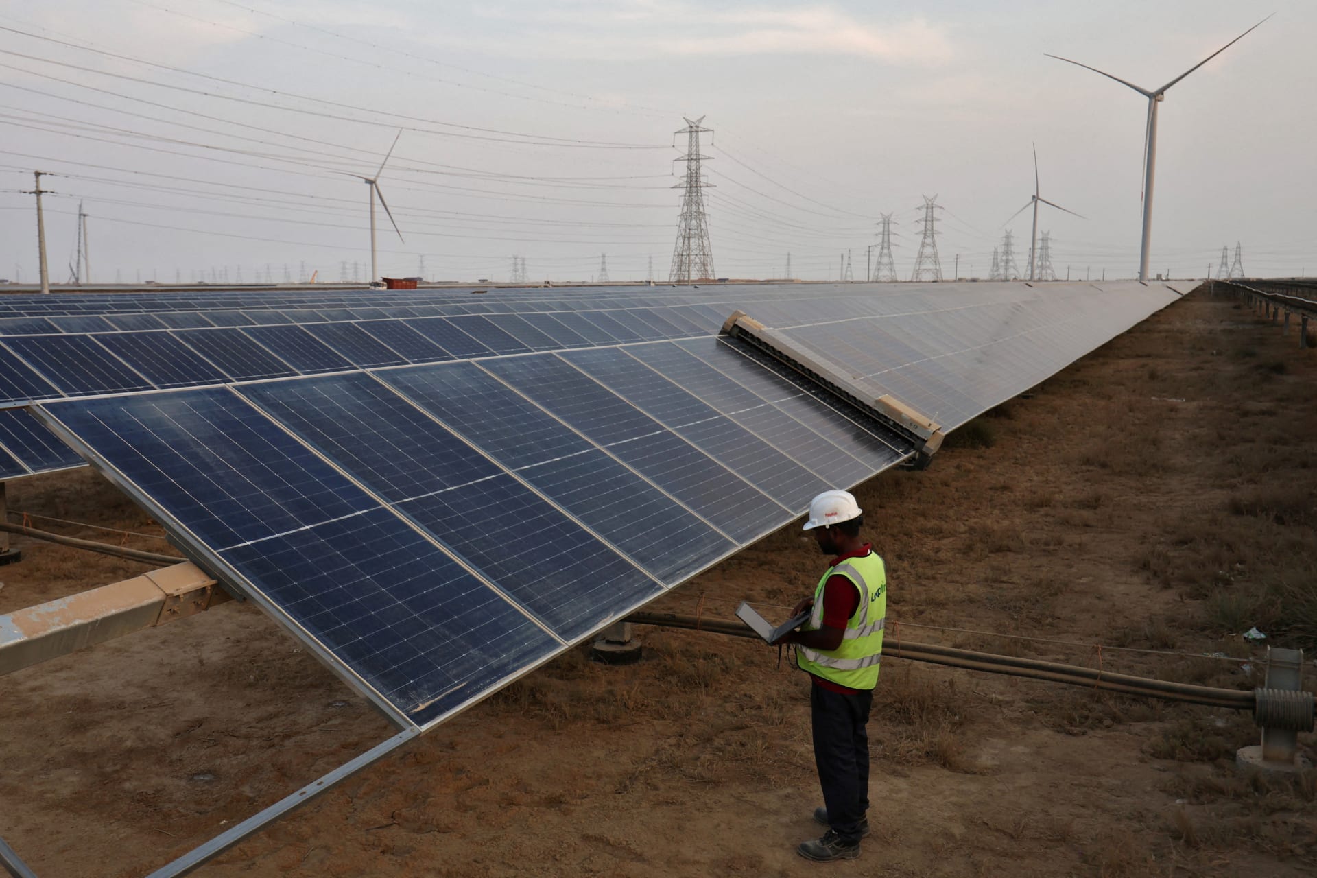 A technician checks the movement of an Automated cleaning brush installed over solar panels