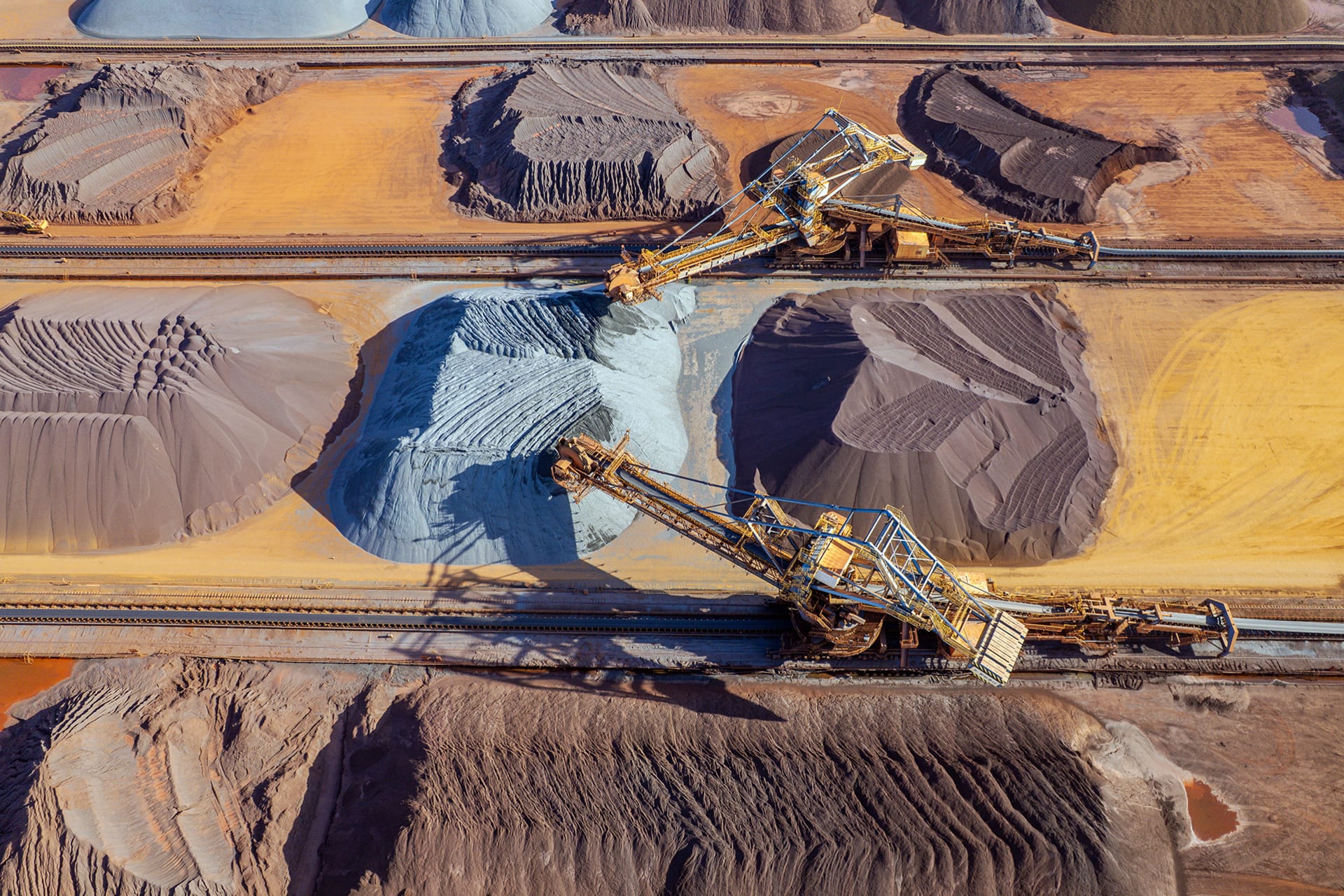 An overhead view shows large machinery at work in a metal mine.