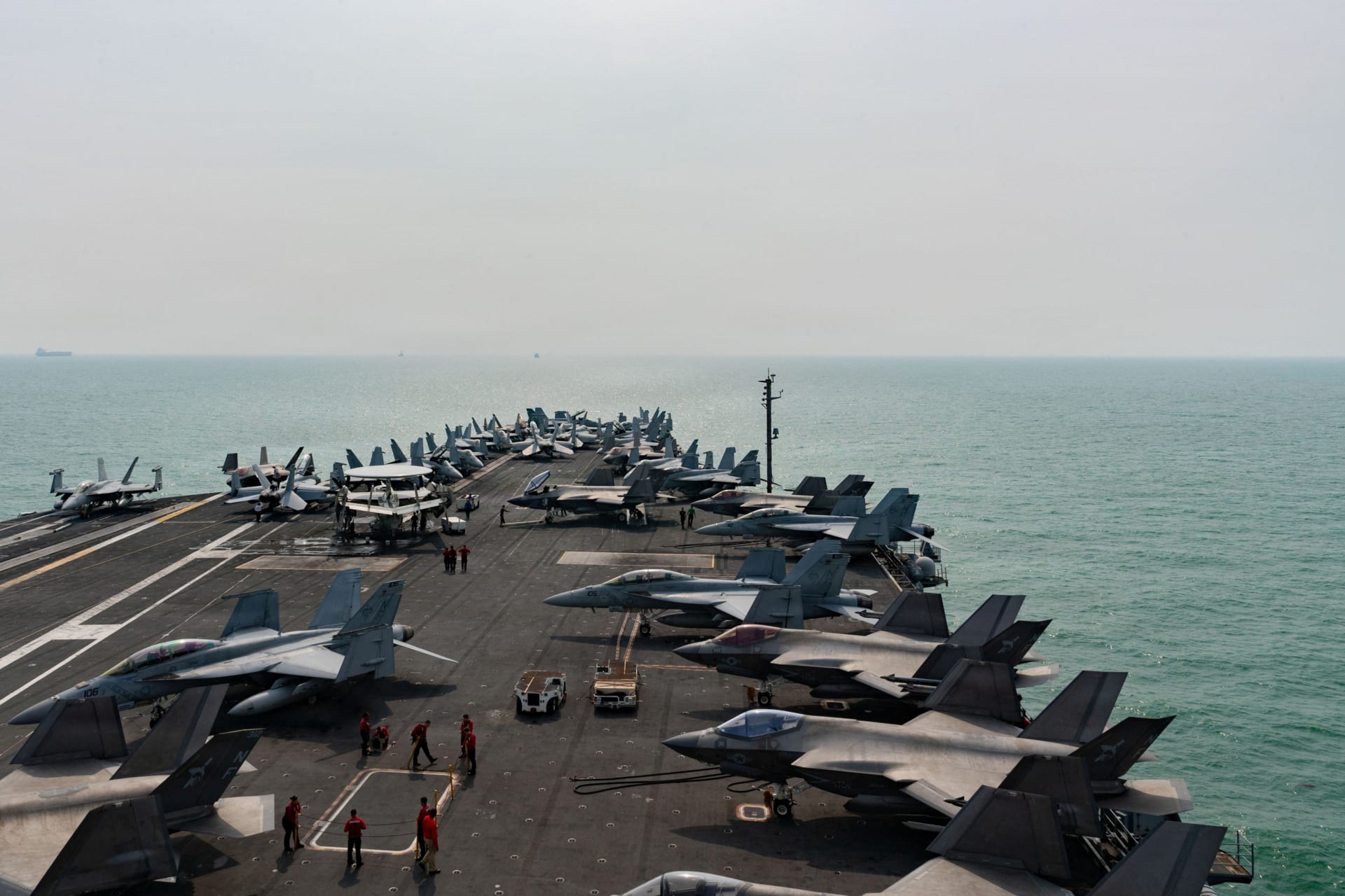 Several fighter jets sit on top of the deck of the The U.S. Navy Nimitz-class aircraft carrier USS George Washington as it transits the Strait of Malacca.