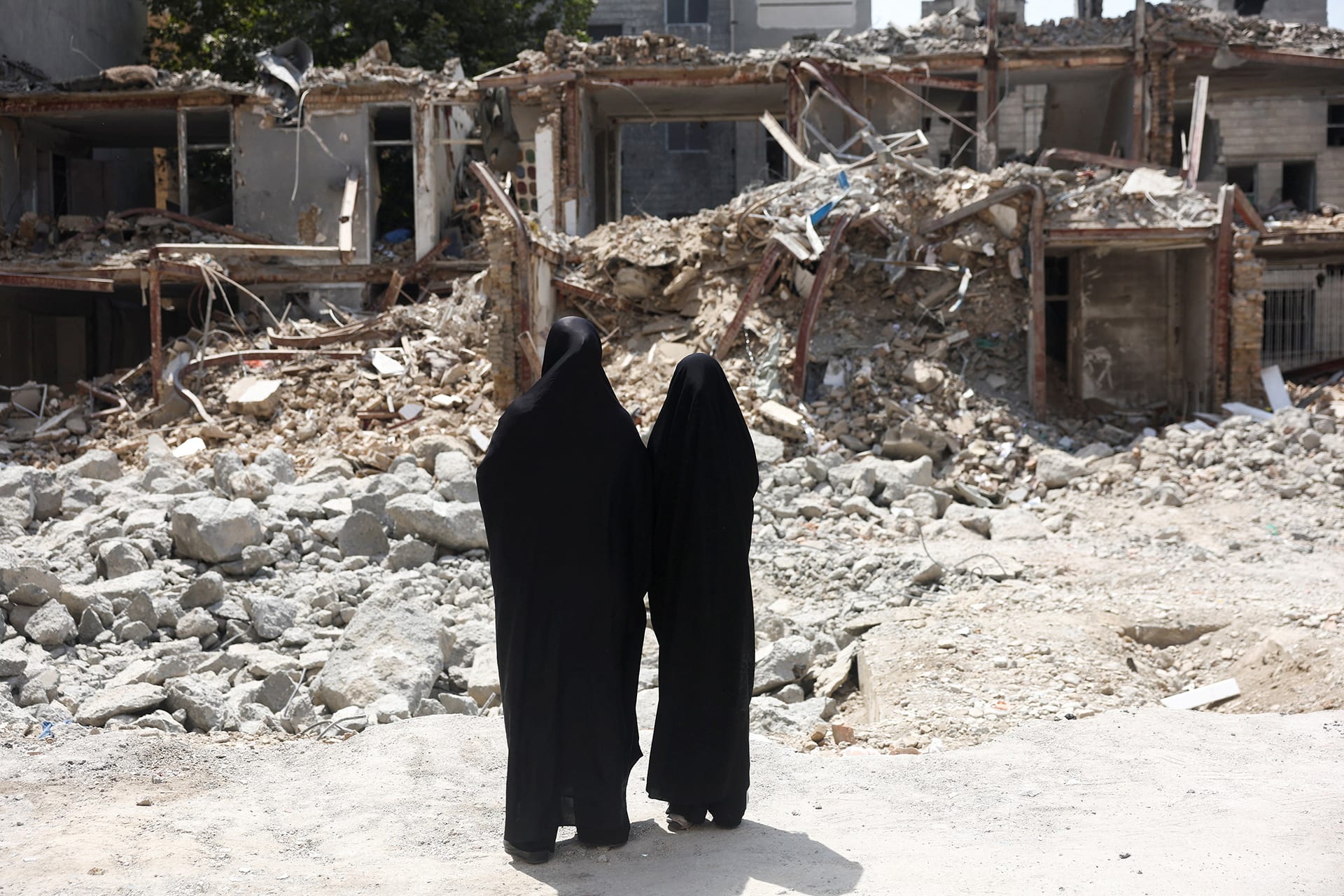 Iranian women look at a building, which was damaged in a U.S. and Israeli strike in March, in Tehran, Iran, August 22, 2026.