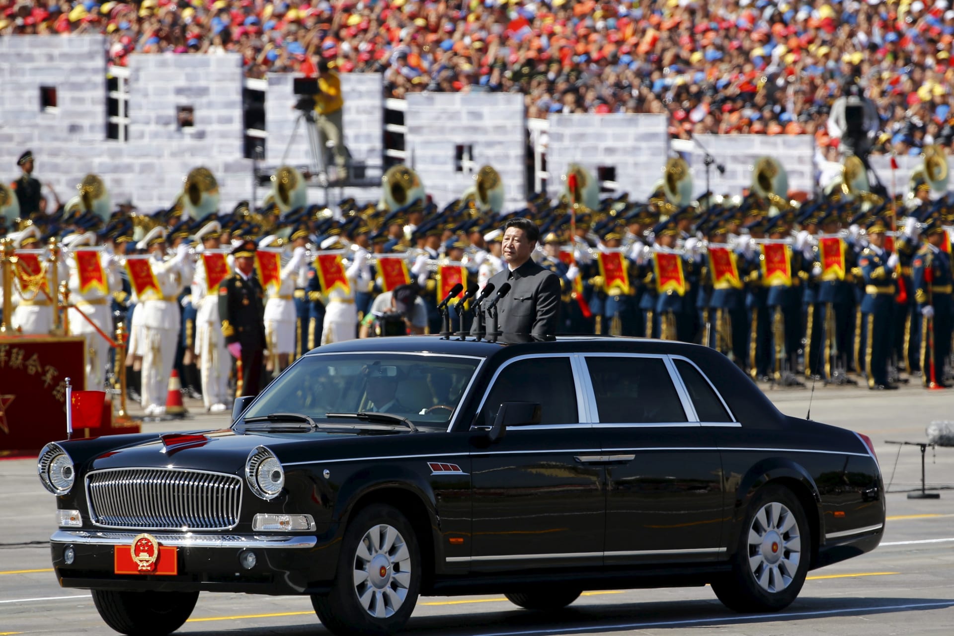 Chinese President Xi Jinping stands in a car, at the beginning of the military parade marking the 70th anniversary of the end of World War Two, in Beijing