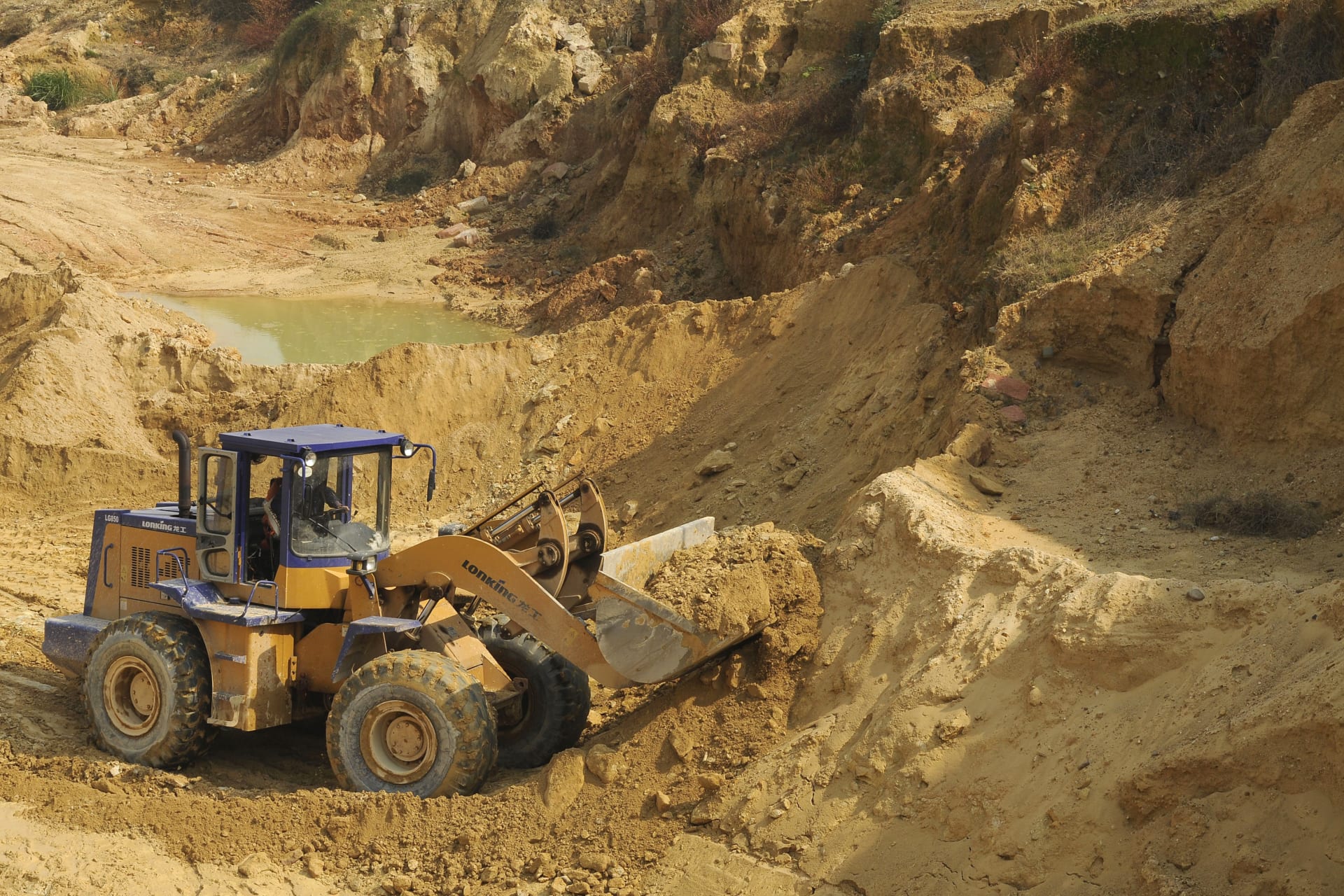 A worker drives a skip loader while working at the site of a rare earth metals mine at Nancheng county, Jiangxi province, on October 31, 2010. REUTERS/Stringer