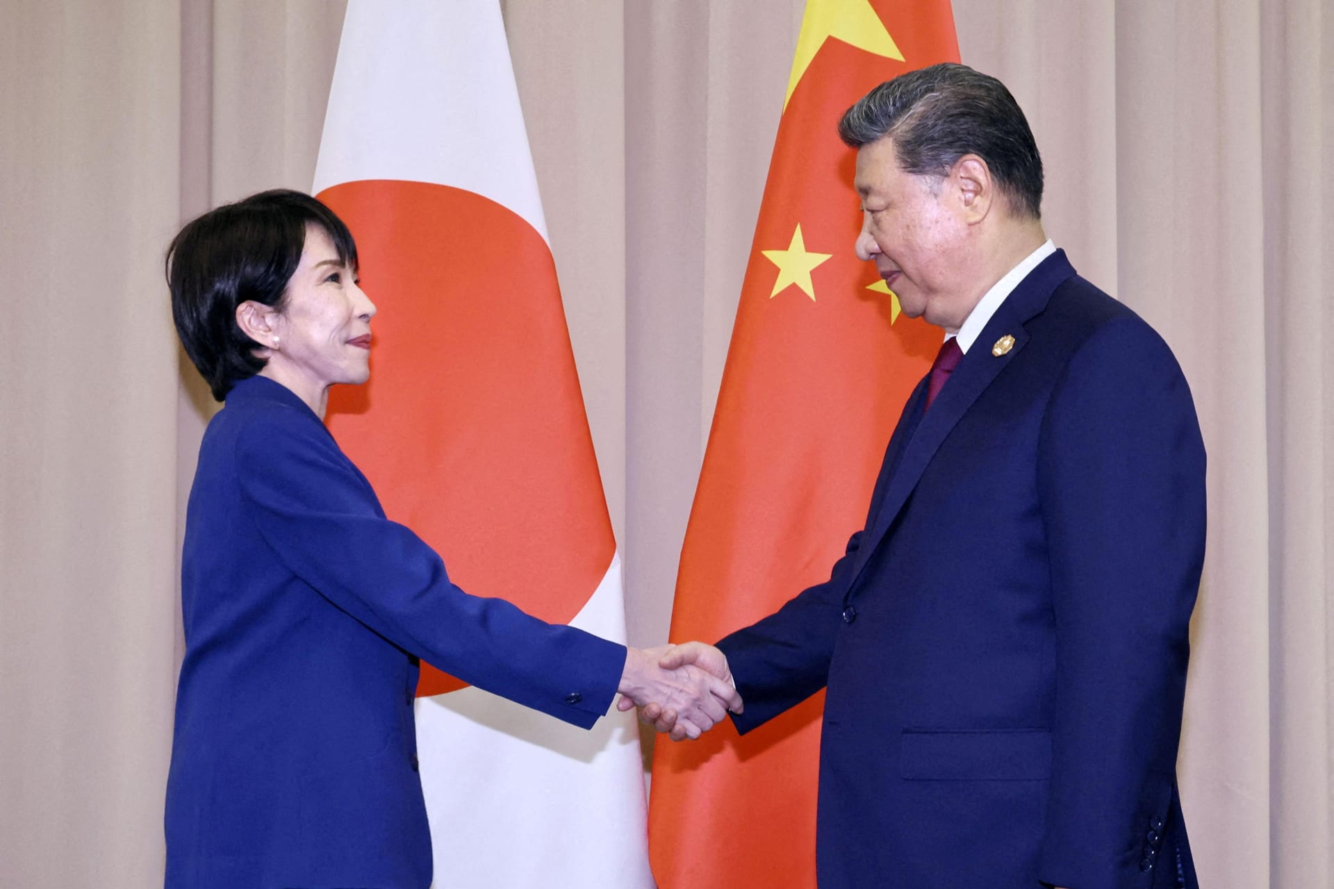Japanese Prime Minister Sanae Takaichi shakes hands with Chinese President Xi Jinping ahead of their talks in Gyeongju, South Korea