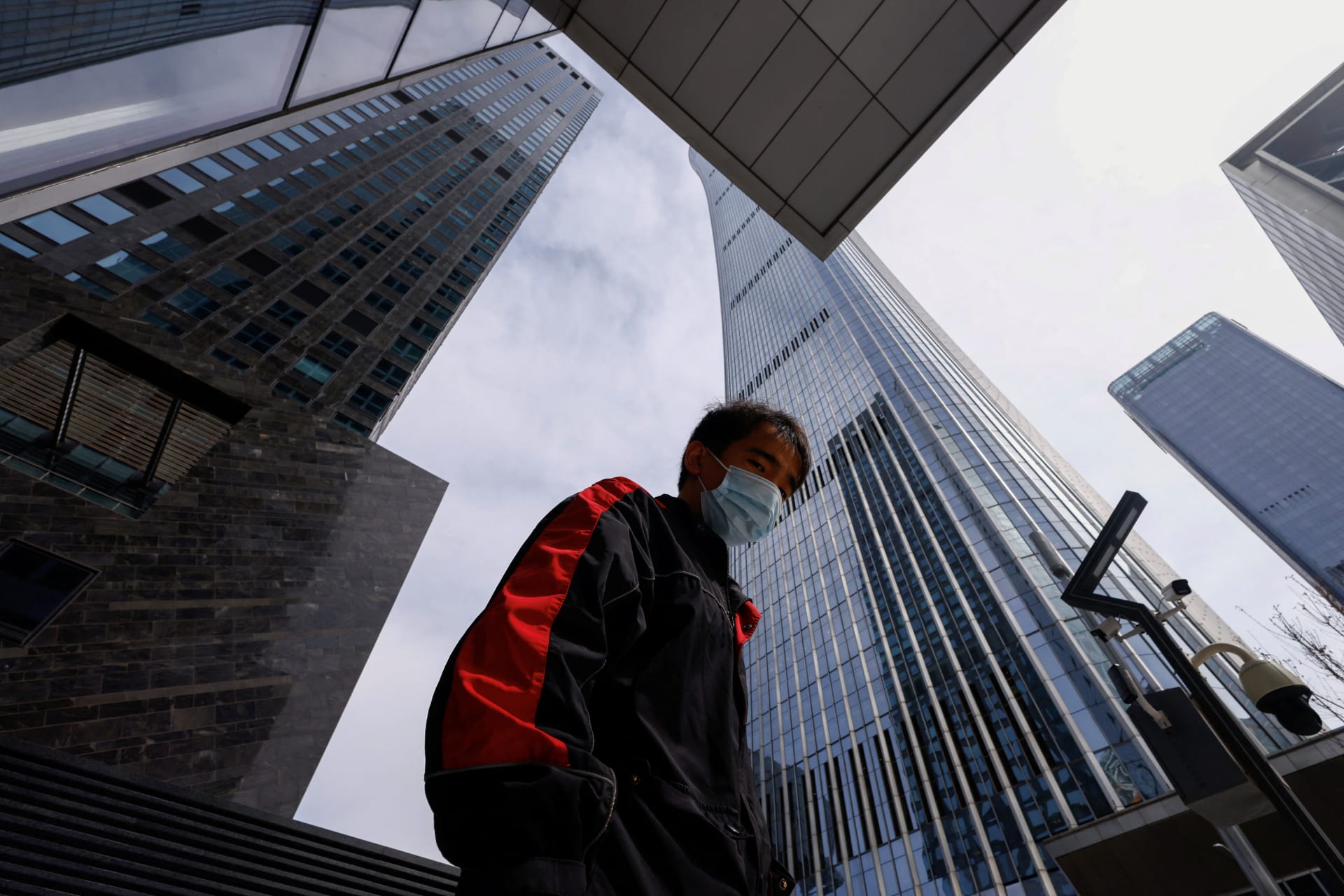 Delivery worker walks past buildings at Central Business District (CBD) in Beijing
