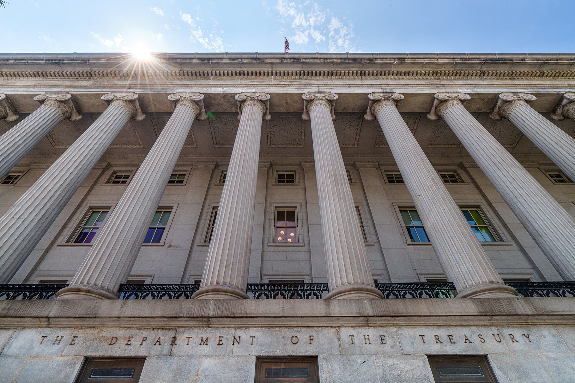 The sun flares over the top of the side entrance to the U.S. Treasury Department Building on August 18, 2024, in Washington, DC.