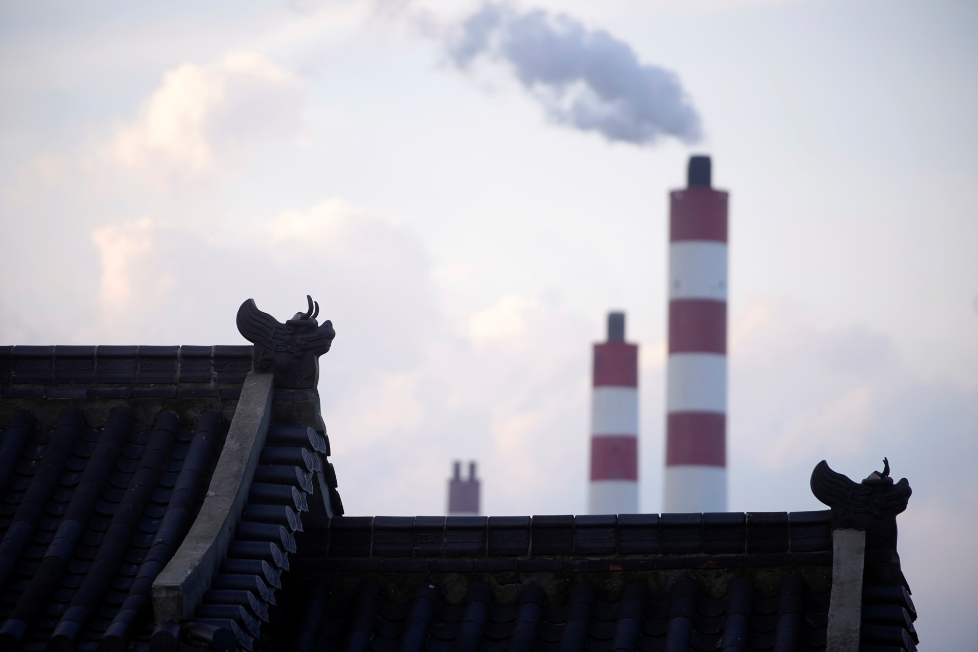 Chimneys of a coal-fired power plant are seen behind a gate in Shanghai, China October 21, 2021. REUTERS/Aly Song