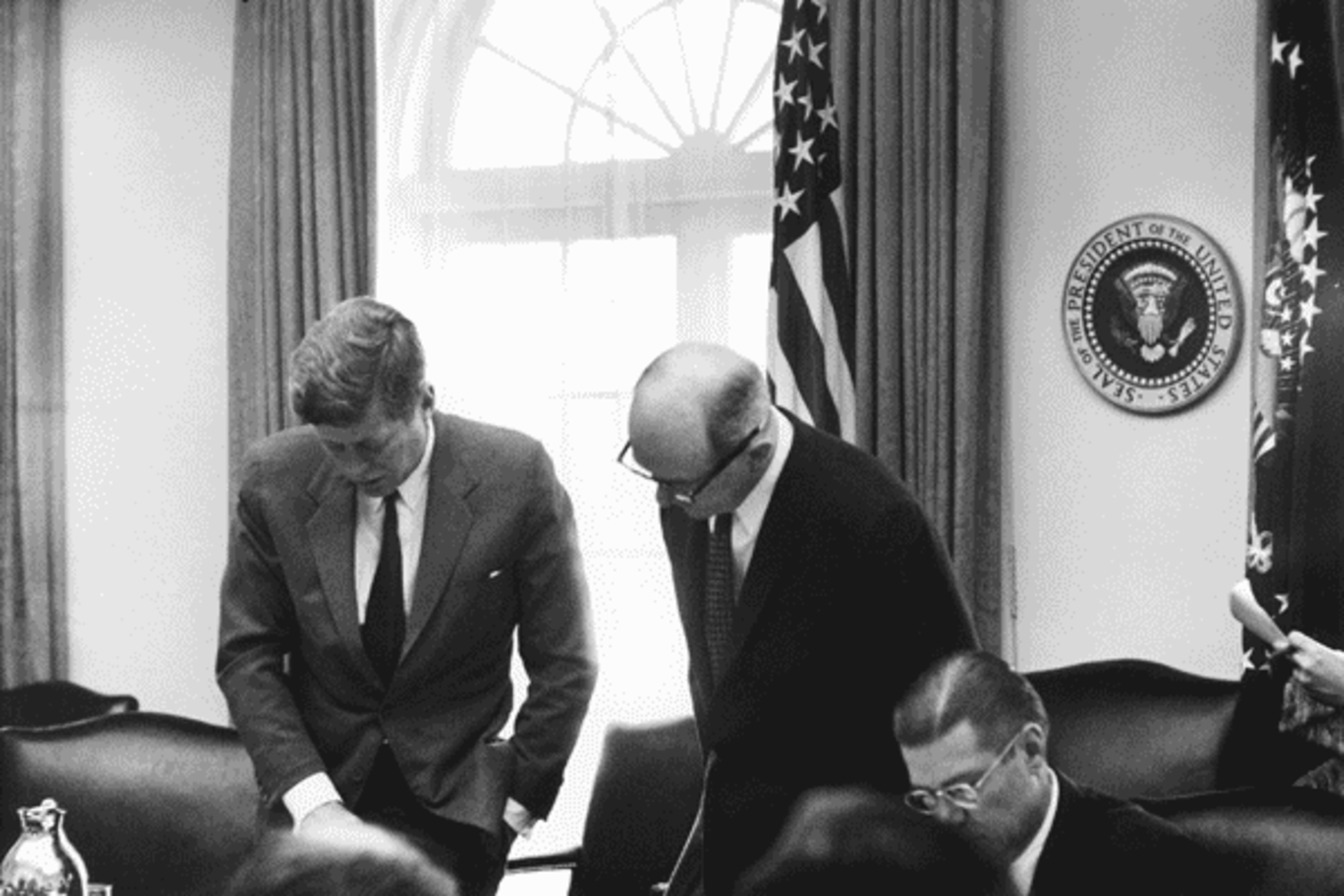 <p>President John F. Kennedy looks over photographs taken of Soviet missile installations in Cuba in the Cabinet Room during a meeting with his national security advisors, October 16, 1962.</p>
